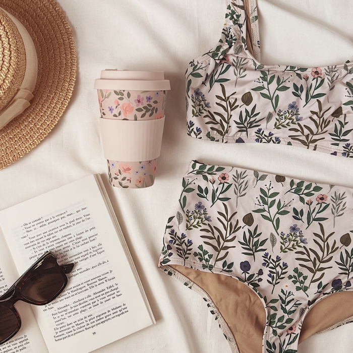 Herboria Mimi & August swimsuit and coffee yo cup From Mimi & August laying on a bed with summer accessories