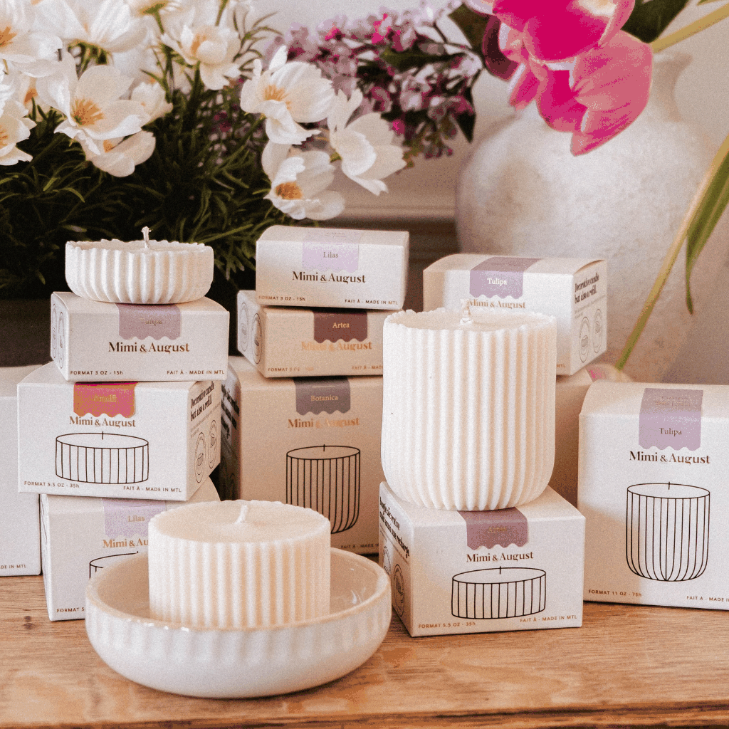 candle refills in cream packaging with ribbed ivory wax inserts displayed beside white flowers and ceramics
