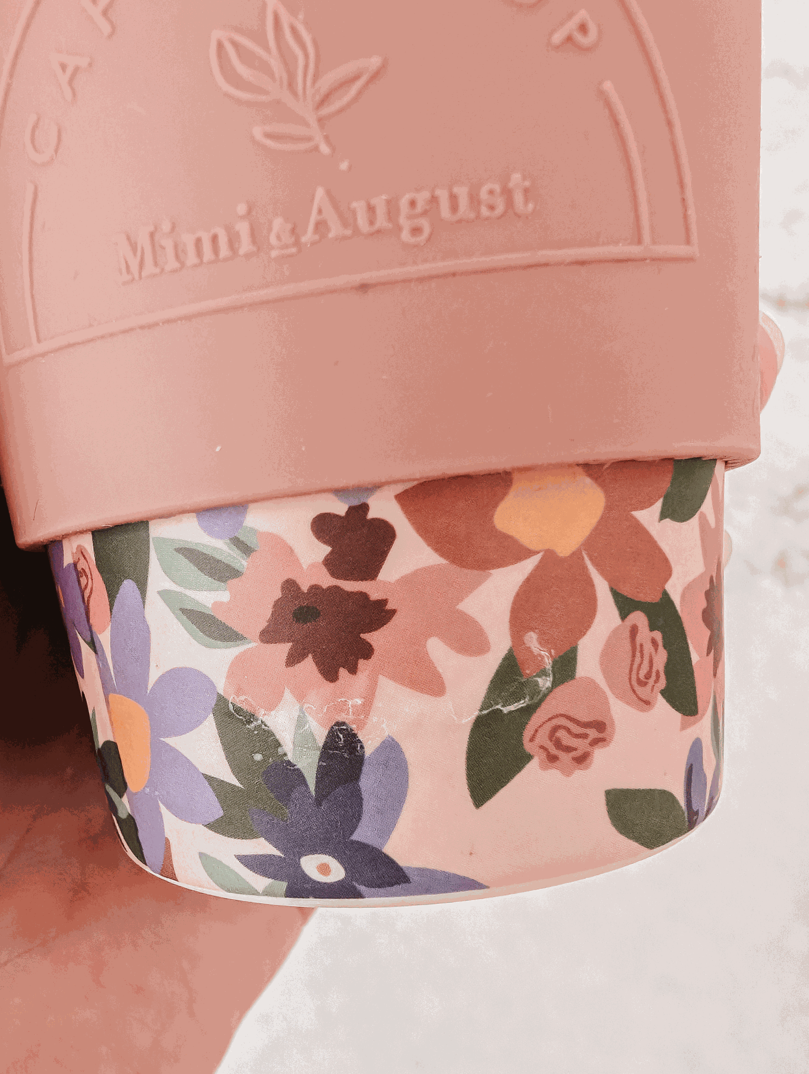 A pink Defect Café Yo Cup from Mimi & August with a floral design on it.