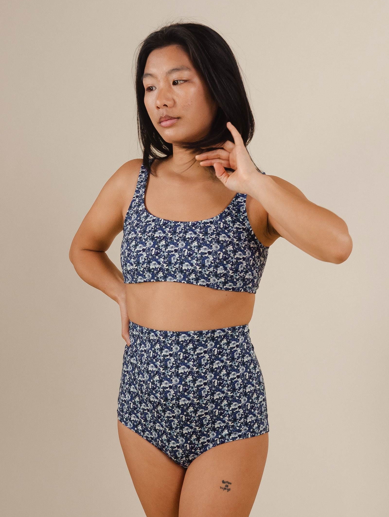 A woman in a blue floral bikini kit by mimi and august