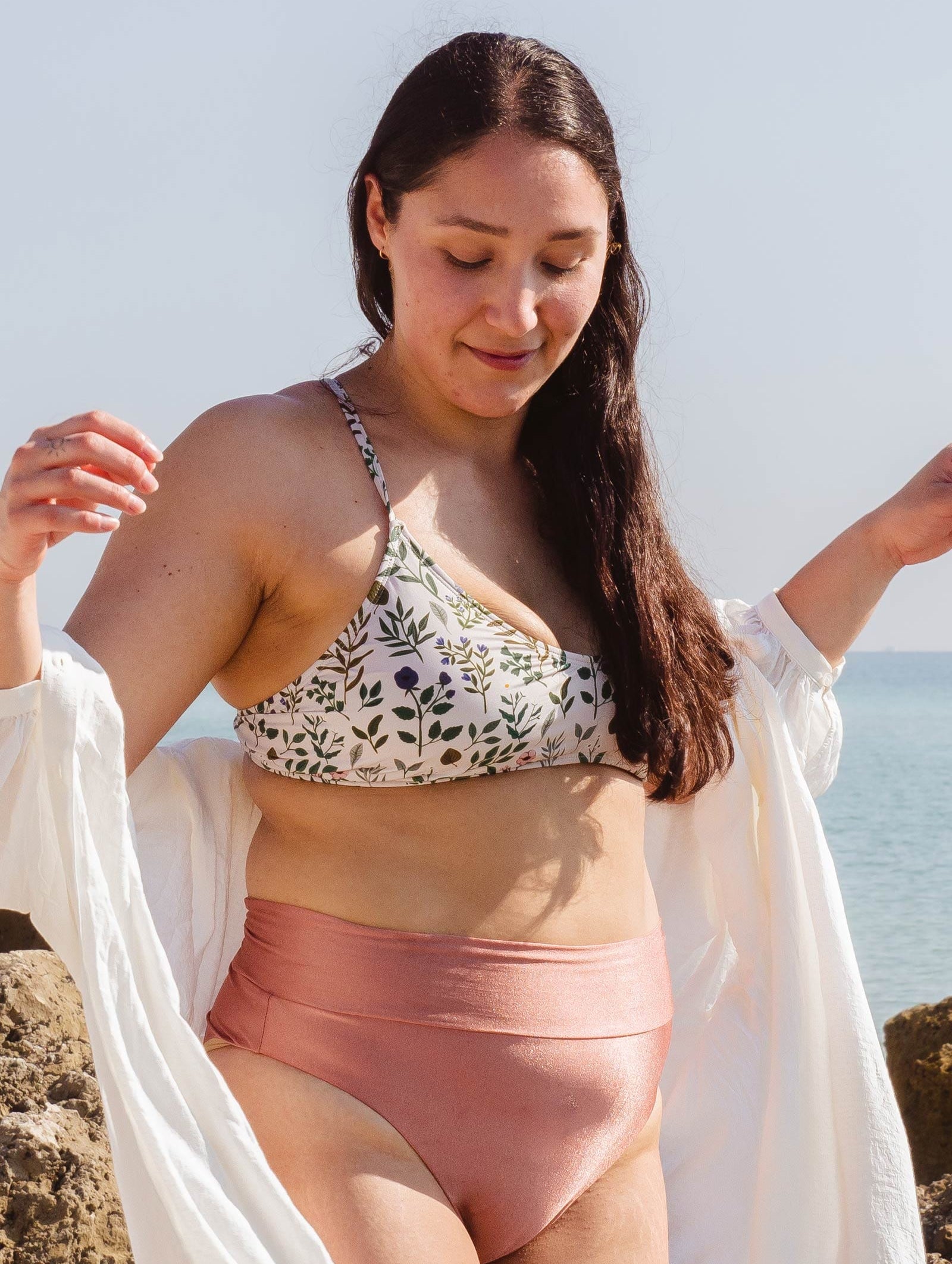 A woman in a Chichi Herboria Bralette Bikini Top standing on Miami Beach.
