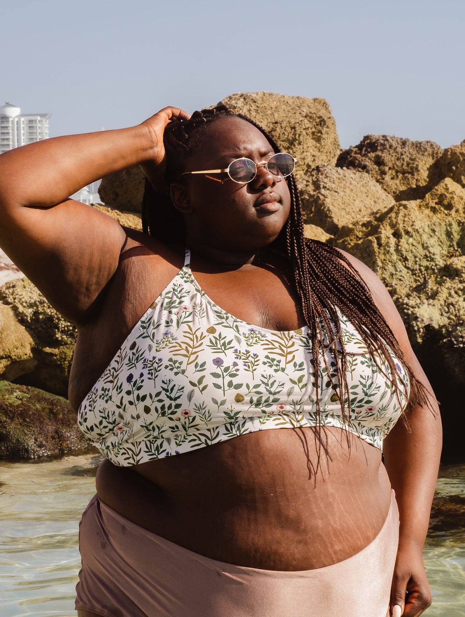 A beautiful woman standing in the water wearing a mimi and august Chichi Herboria Bralette Bikini Top.