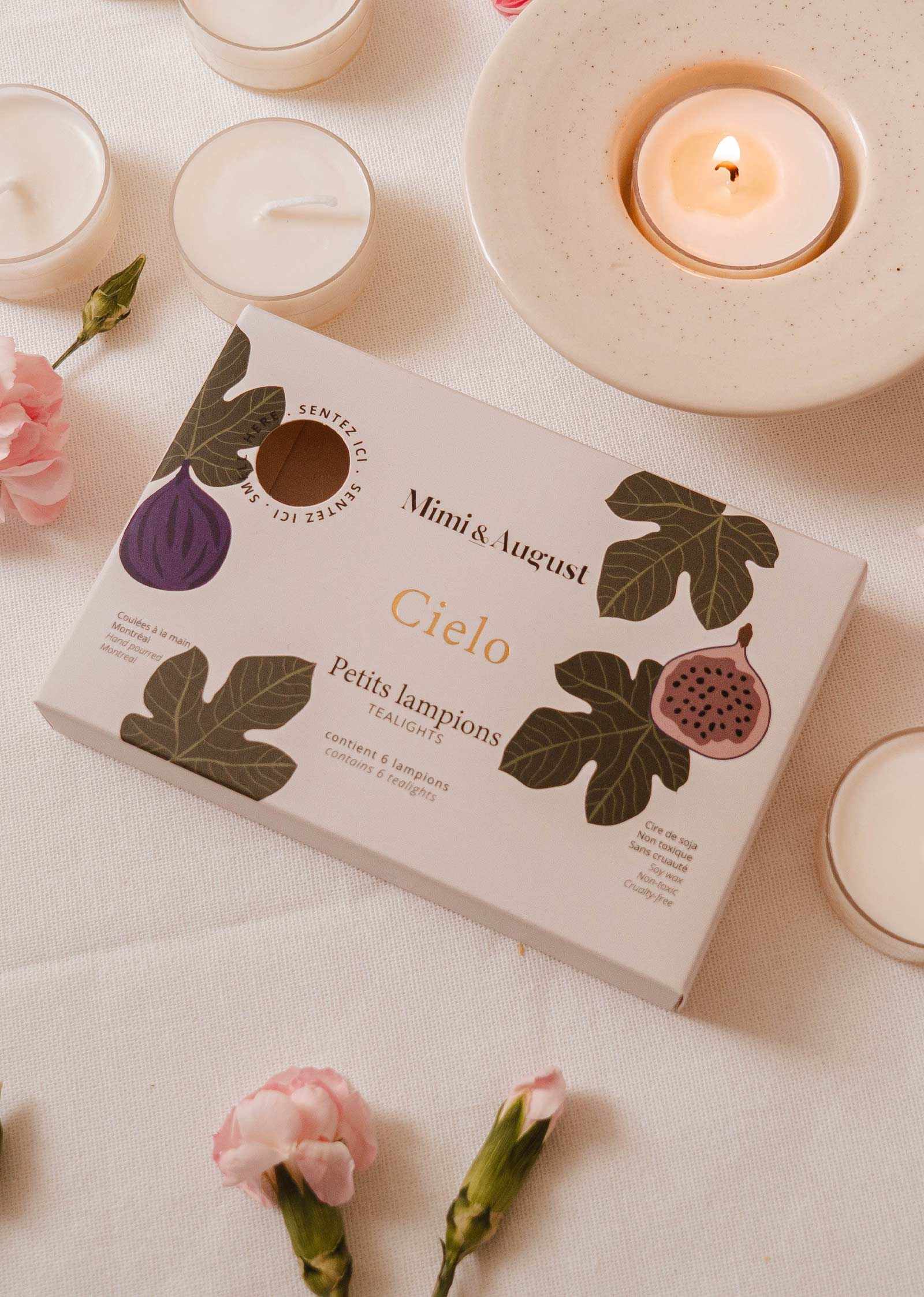 Le coffret de lampions figue Cielo de Mimi & August avec des fleurs roses et un lampion allumé sur une soucoupe.
