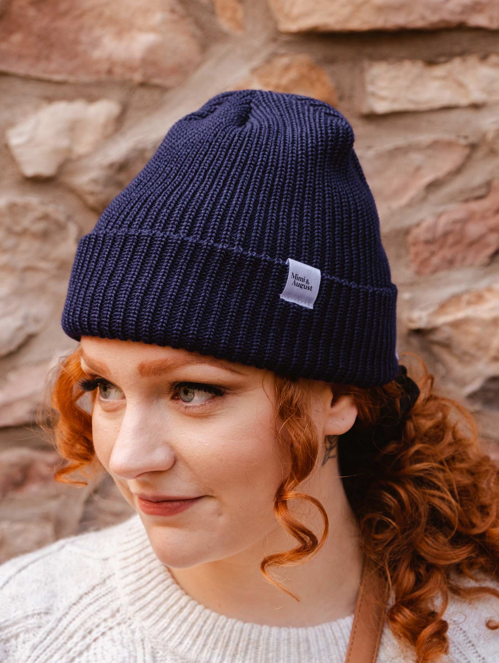 A woman wearing a Deep Blue Cuffed Beanie by mimi and august