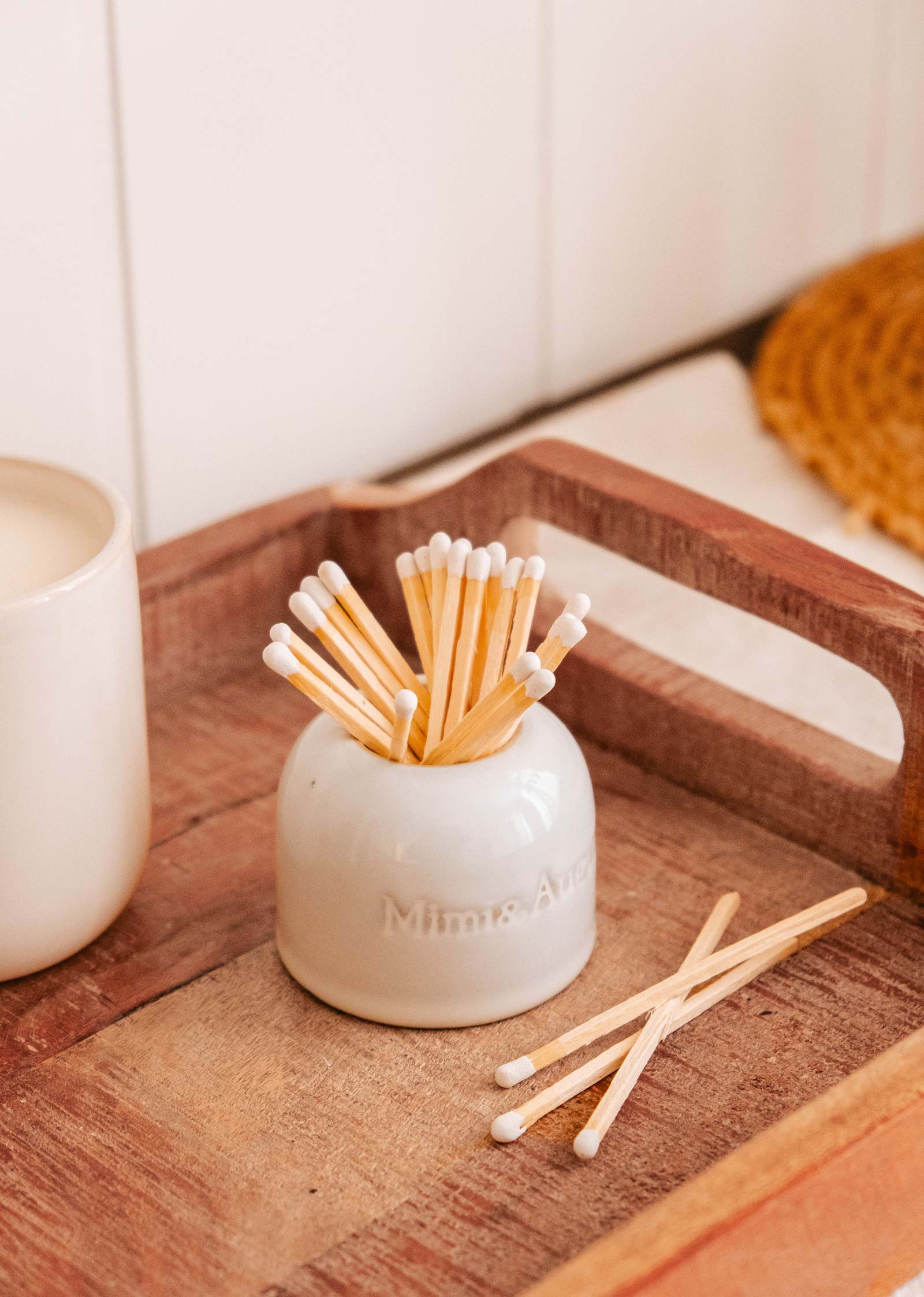 The Étincelles – Ceramic Match Holder from Mimi & August, featuring cotton swabs, rests on a wooden tray and adds charm alongside a white cup.