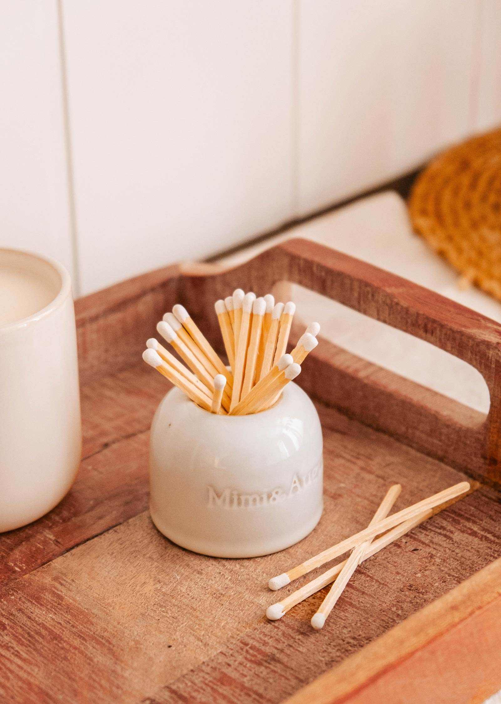 The Étincelles – Ceramic Match Holder from Mimi & August, featuring cotton swabs, rests on a wooden tray and adds charm alongside a white cup.