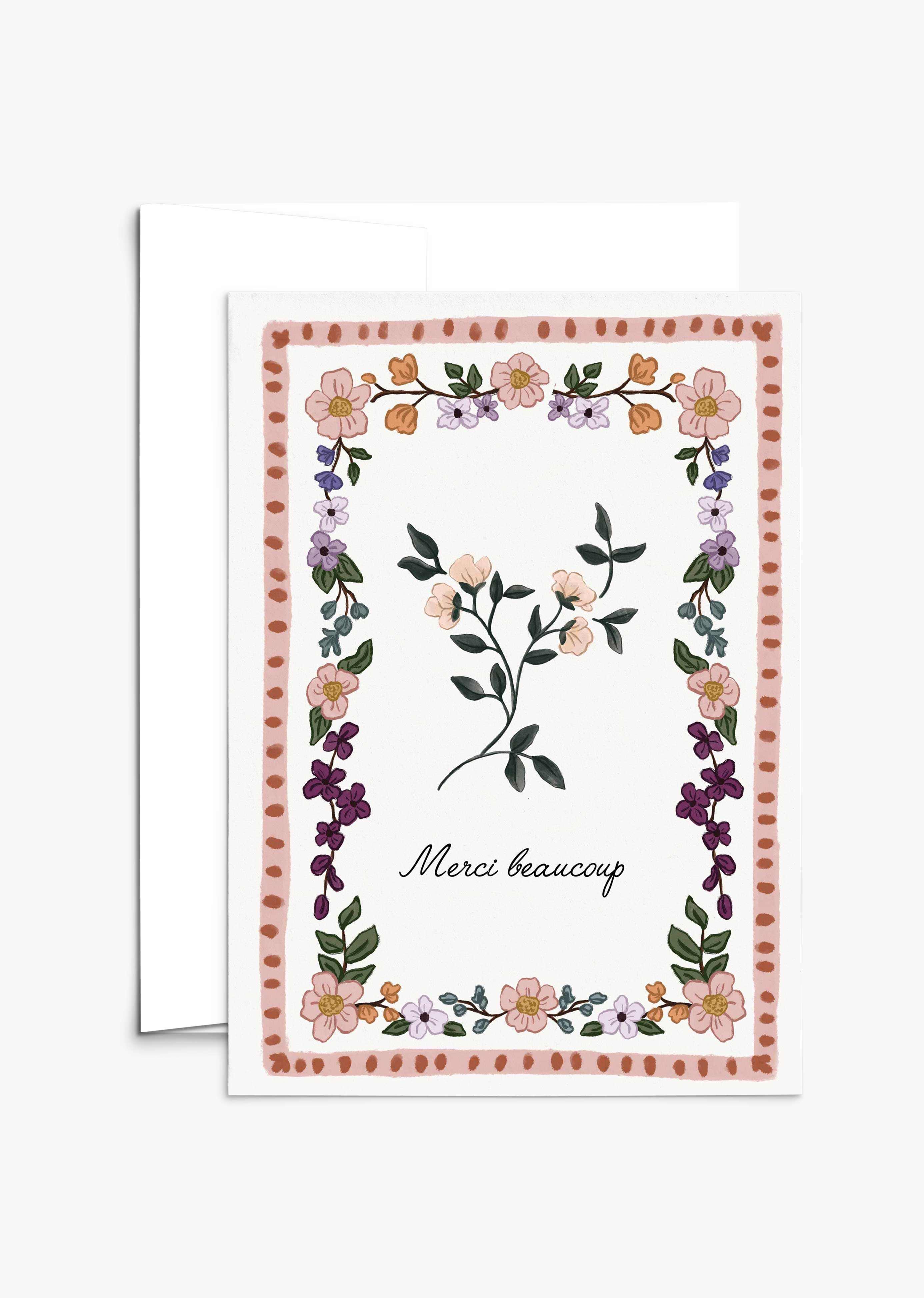 The Floral Thank You Greeting Card by Mimi & August features a vintage floral design with a charming border, central flower, and "Merci beaucoup" in cursive. This blank card is ideal for heartfelt notes and gratitude.