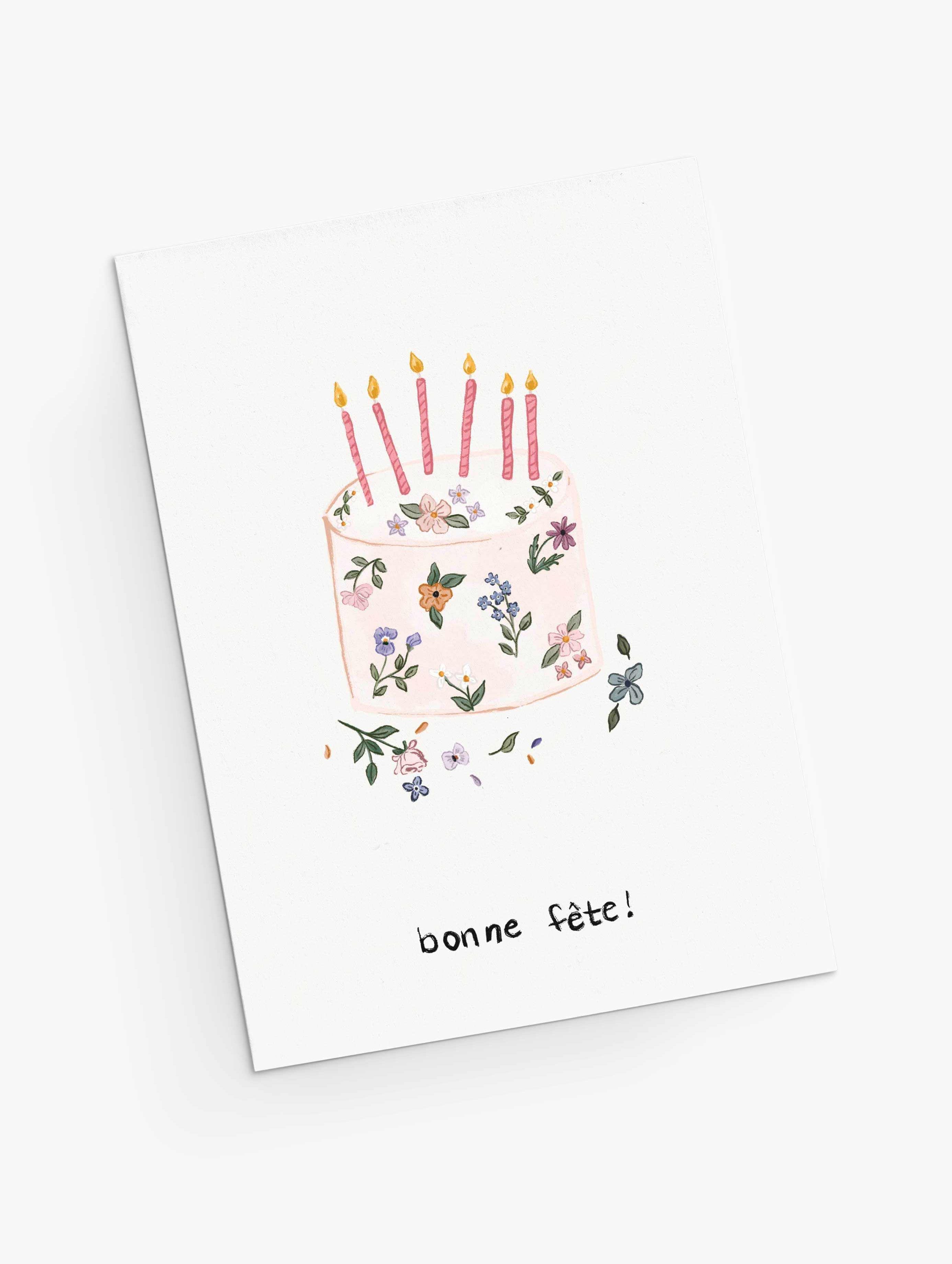 The Mimi & August Floral Birthday Cake Greeting Card features hand-drawn flowers in a cake design with five lit candles and "bonne fête!" below, printed on recycled paper.