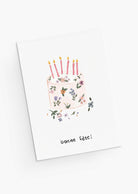 The Mimi & August Floral Birthday Cake Greeting Card features hand-drawn flowers in a cake design with five lit candles and "bonne fête!" below, printed on recycled paper.