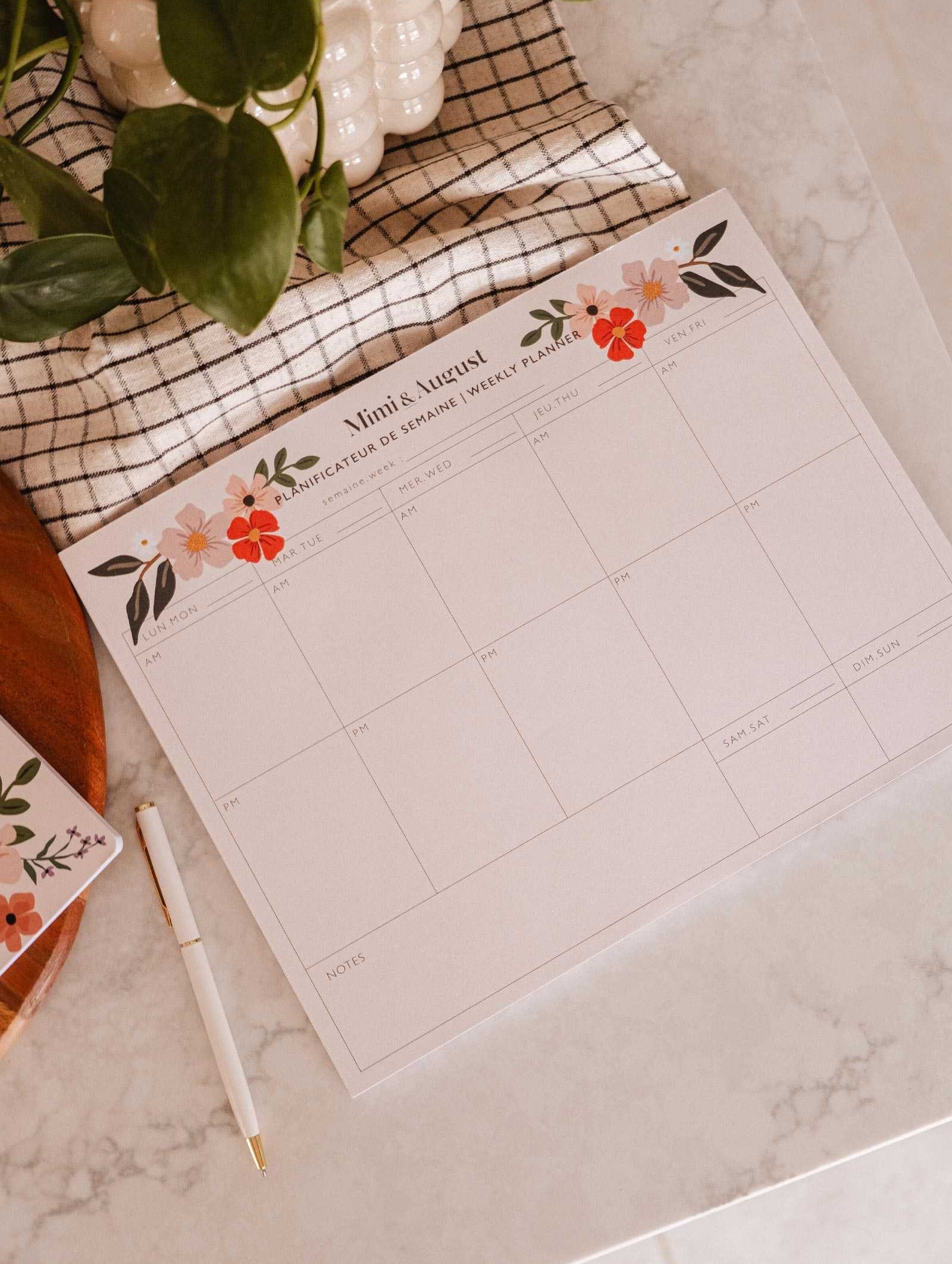 Flower Bomb Weekly Planner open on desk with floral design and eco-friendly features