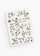 The Mimi & August Blue Flower Mother's Day Greeting Card features hand-drawn blue florals and green leaves framing the French text "Bonne fête des mères" on a white background, printed on recycled paper for an eco-friendly touch.