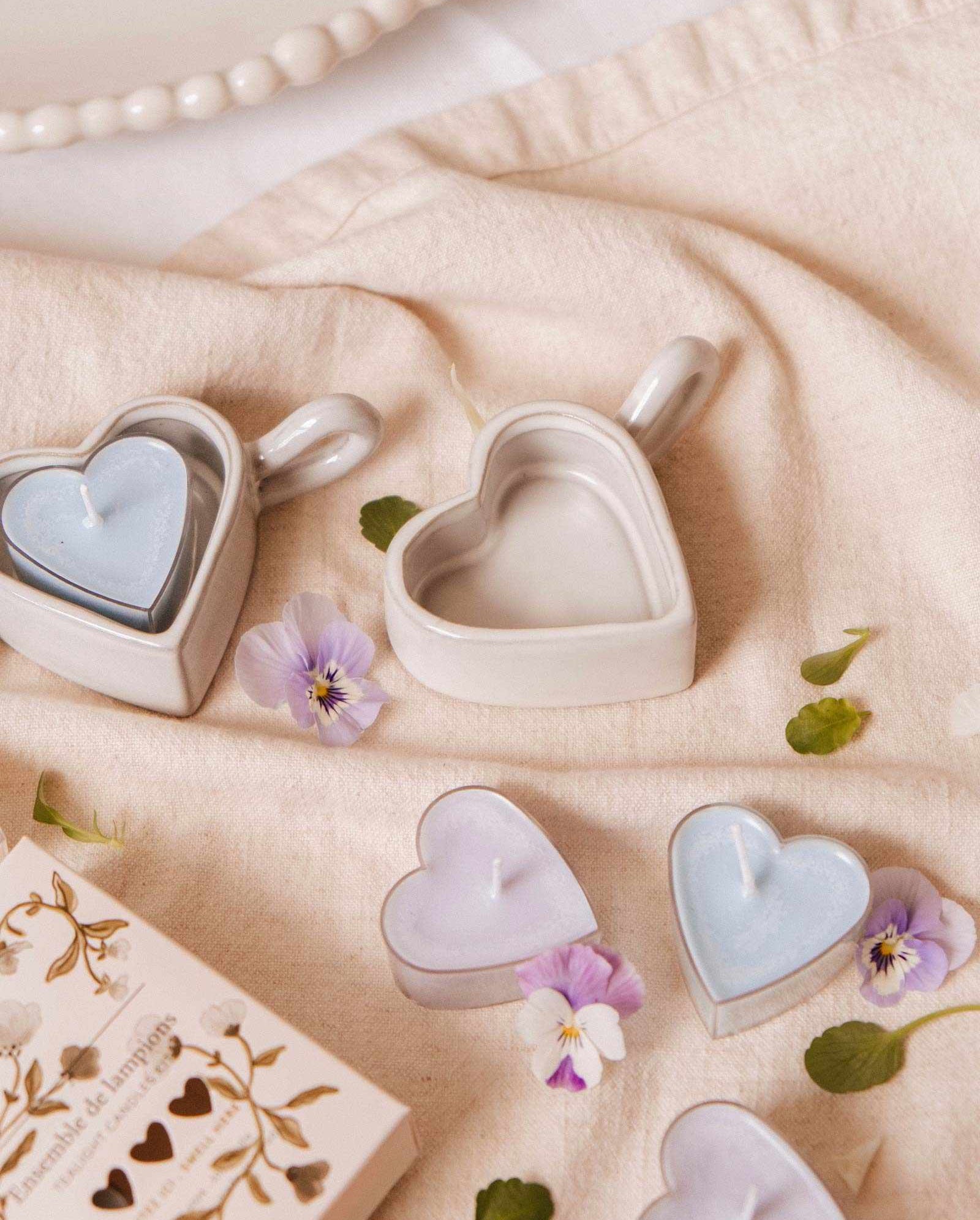 The Mimi & August Heart & Glow Tealight Holder is styled on fabric with delicate flowers and a decorative box, creating a charming heart-themed display.