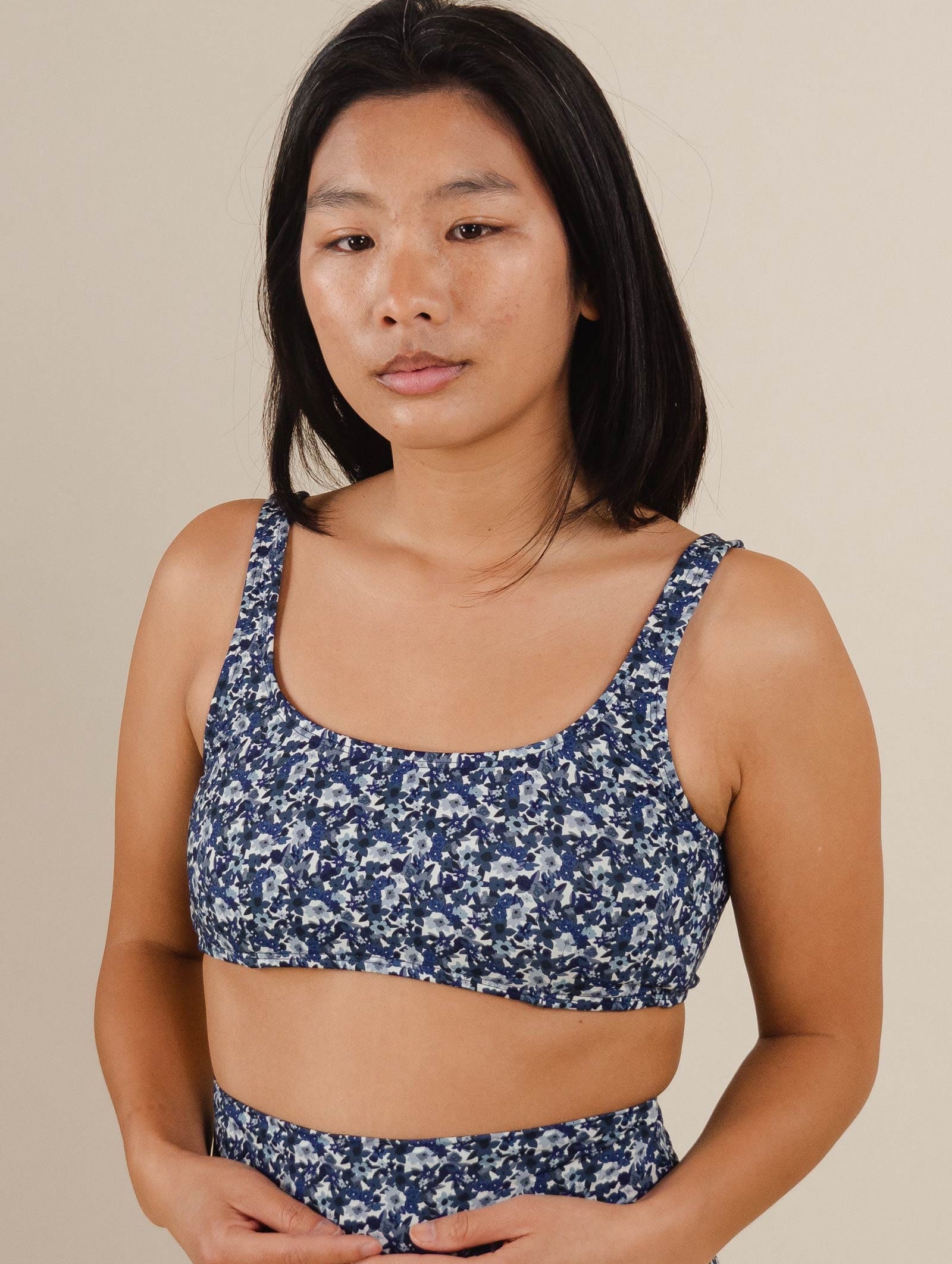 A woman in a blue floral bralette bikini top.