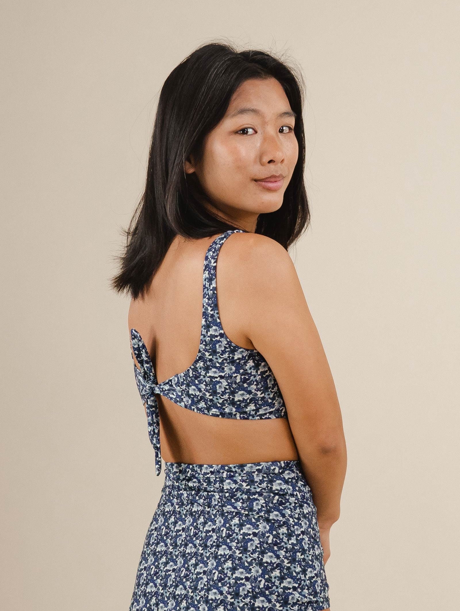 A asian woman in a Lima Moonflower Bralette Bikini Top with an adjustable knot.