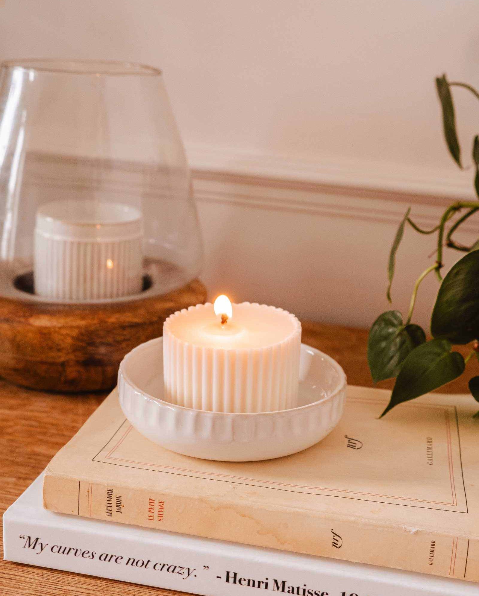 Handcrafted little ceramic candle holder nest holding a candle refill with minimalist textured design