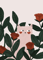 The Lovey Dovey Cat Art Print by Mimi & August features a cute pink cat with heart-shaped cheeks, surrounded by red roses and green leaves, capturing the essence of whimsy in a garden setting.