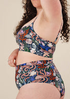 A woman wearing a marine life print bikini top and bottom in shades of blue.