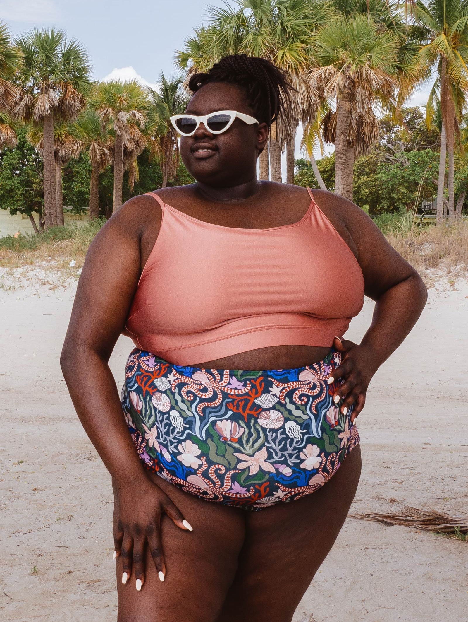 A woman in a Mimi and August Sunset Bralette Bikini Top and floral print bikini bottom