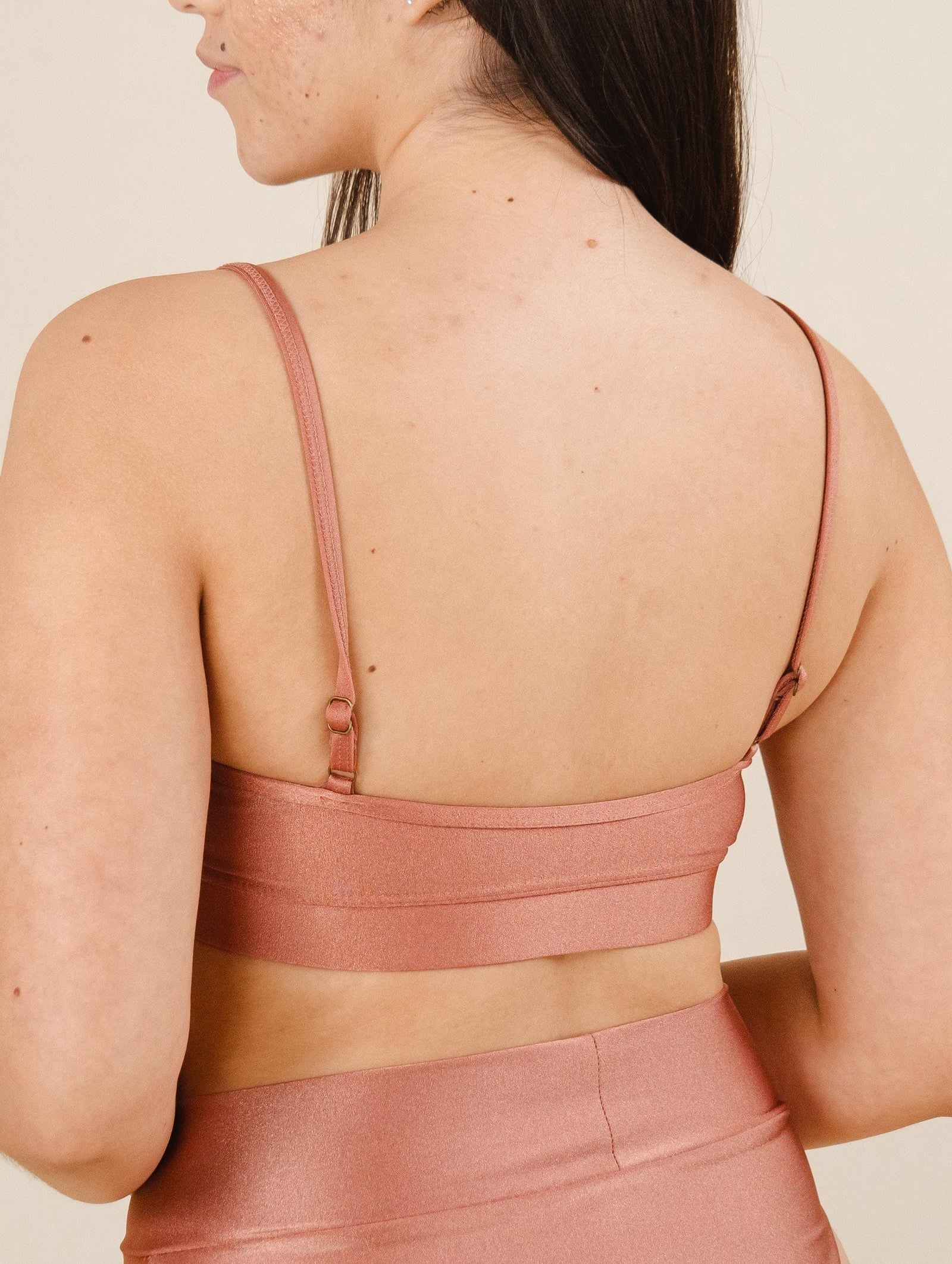 A woman in a comfortable coral bikini top print.