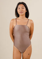 A woman in a Nohea Dunes One-Piece Swimsuit with a tattoo in her leg.