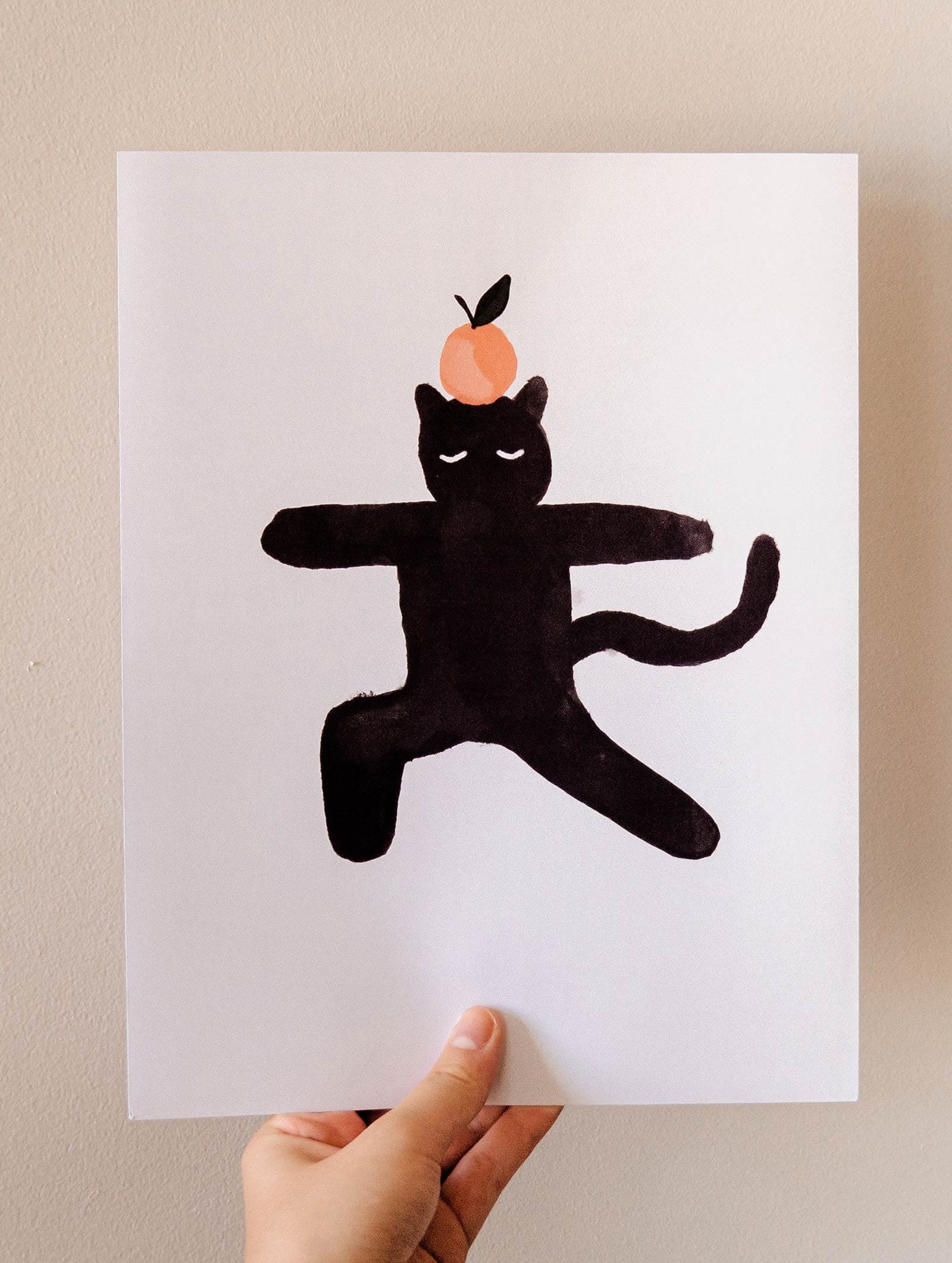 An Orange Black Cat Art Print from Mimi & August, perfect for cat-lovers.