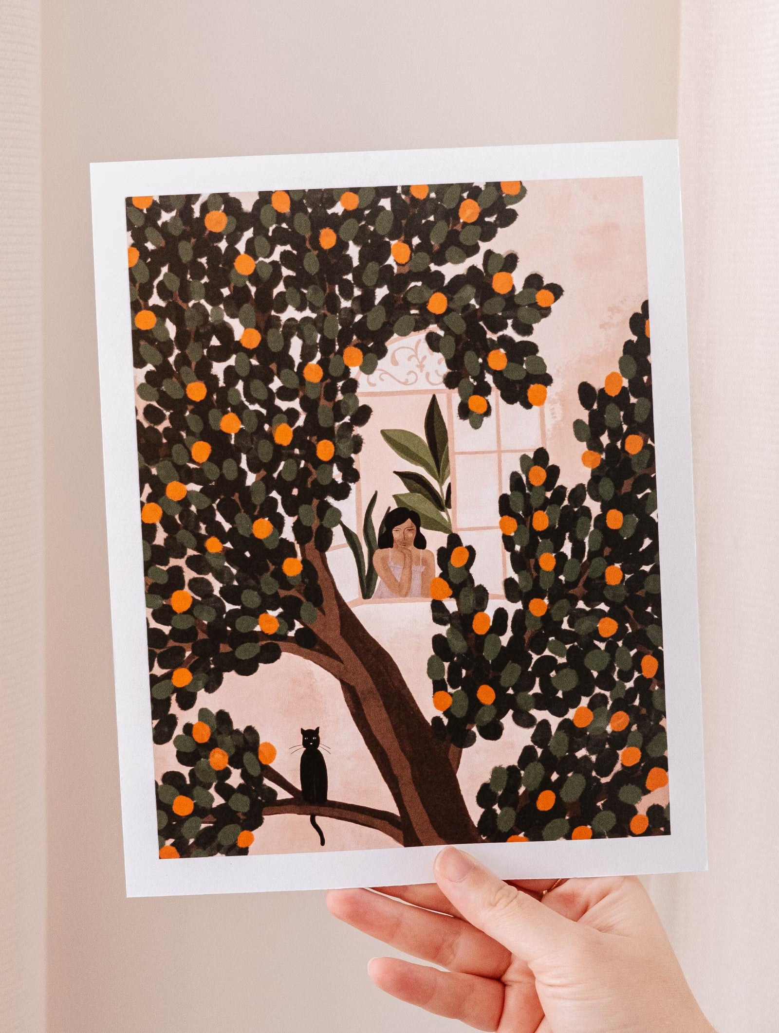 A woman admiring a vibrant Mimi & August Orange Tree Art Print.