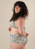 A woman in a Herboria High Waist Bikini Bottom and bikini top posing for a picture.