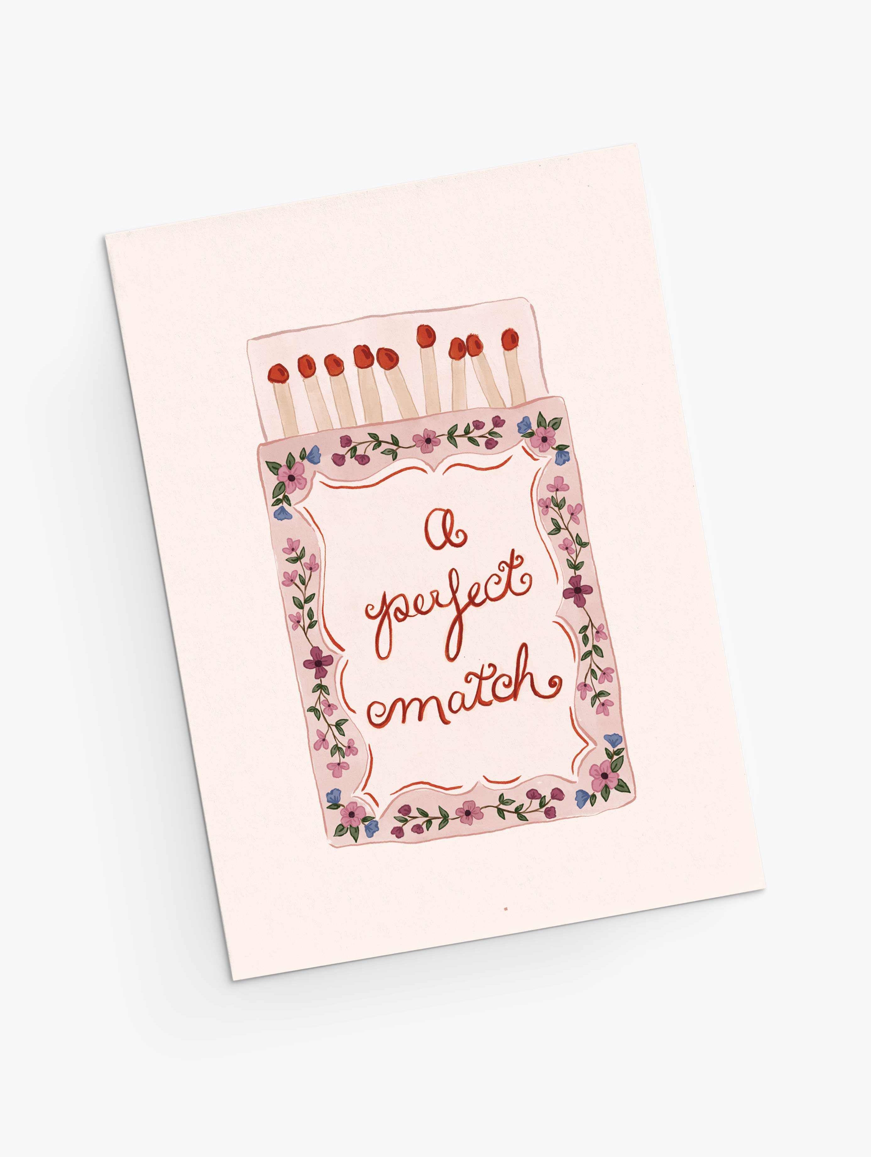 The Perfect Match Greeting Card by Mimi & August features a matchbox and floral border with "A perfect match." Printed on recycled paper, it’s an eco-friendly way to share heartfelt Valentine's Day wishes.
