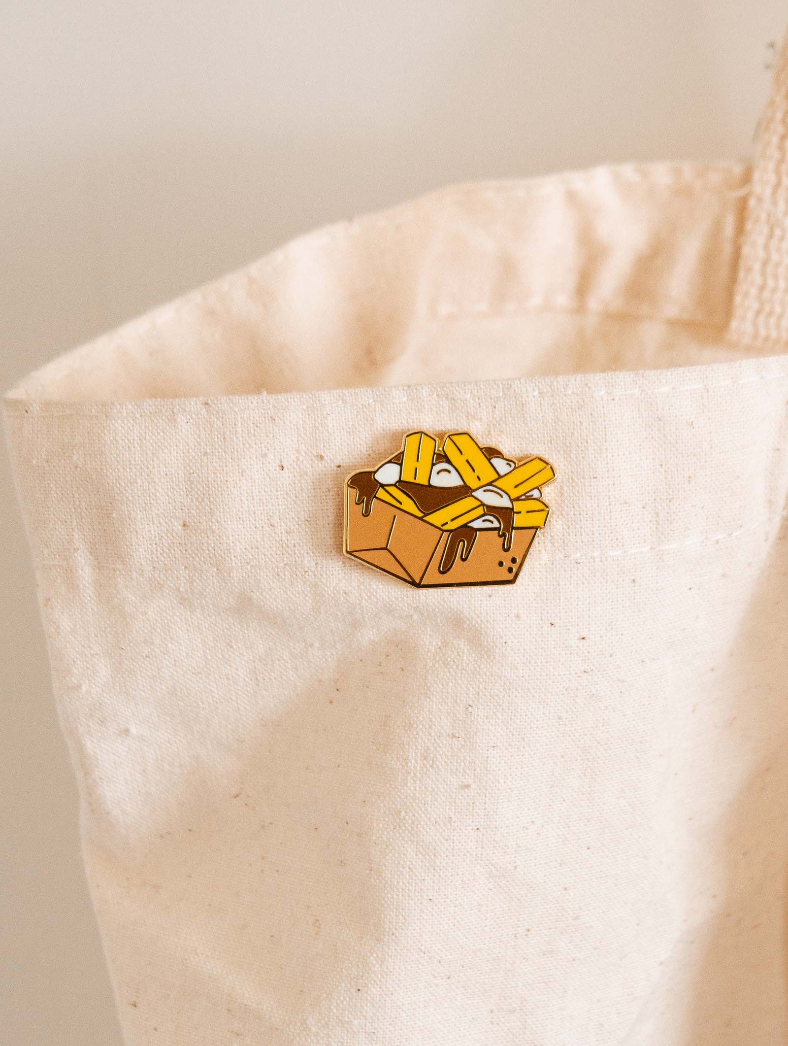 A Poutine in a white tote bag by mimi and august.