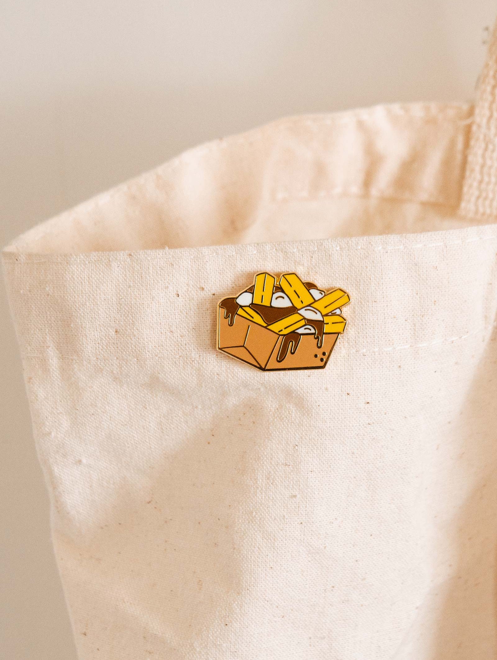A Poutine in a white tote bag by mimi and august.