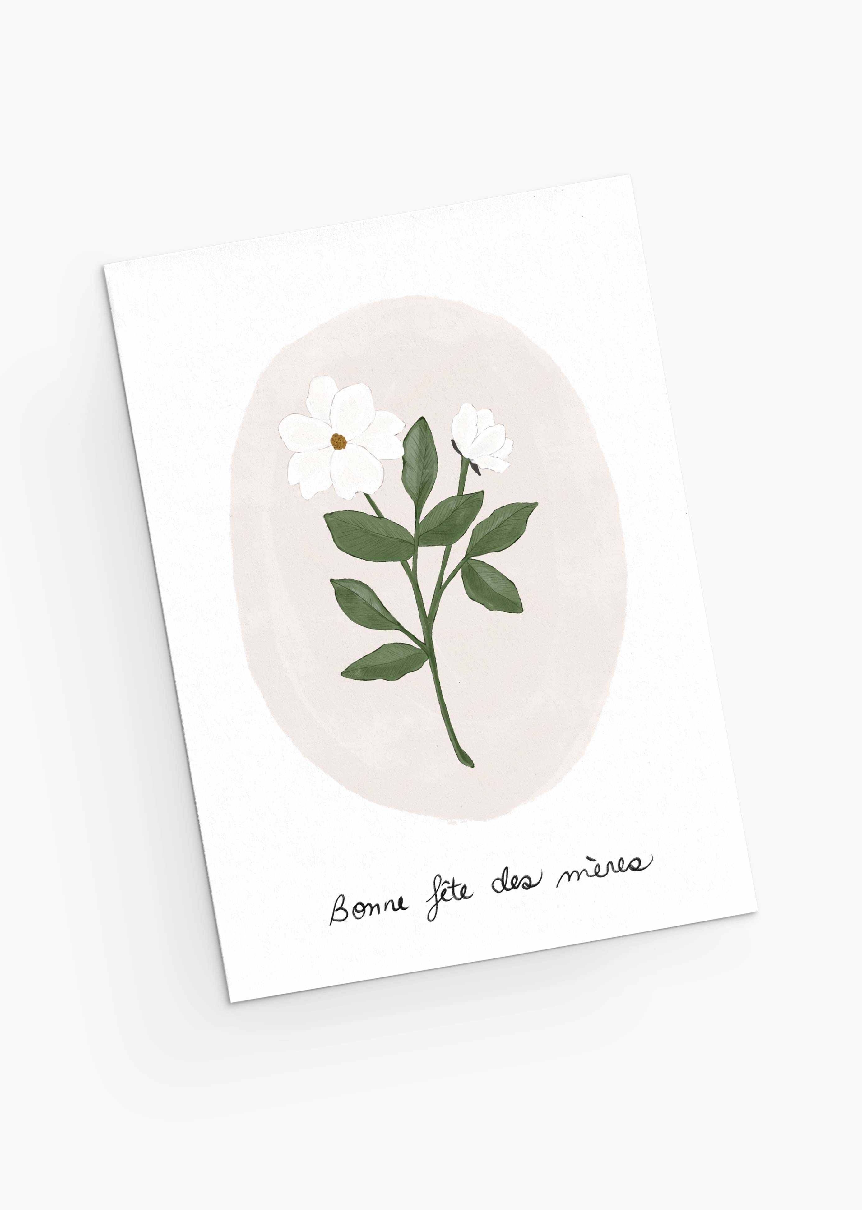 The White Flower Mother's Day Greeting Card from Mimi & August is crafted from recycled paper, featuring a white flower and green leaves illustration with the French greeting "Bonne fête des mères," conveying the delicate charm of pastel blooms.