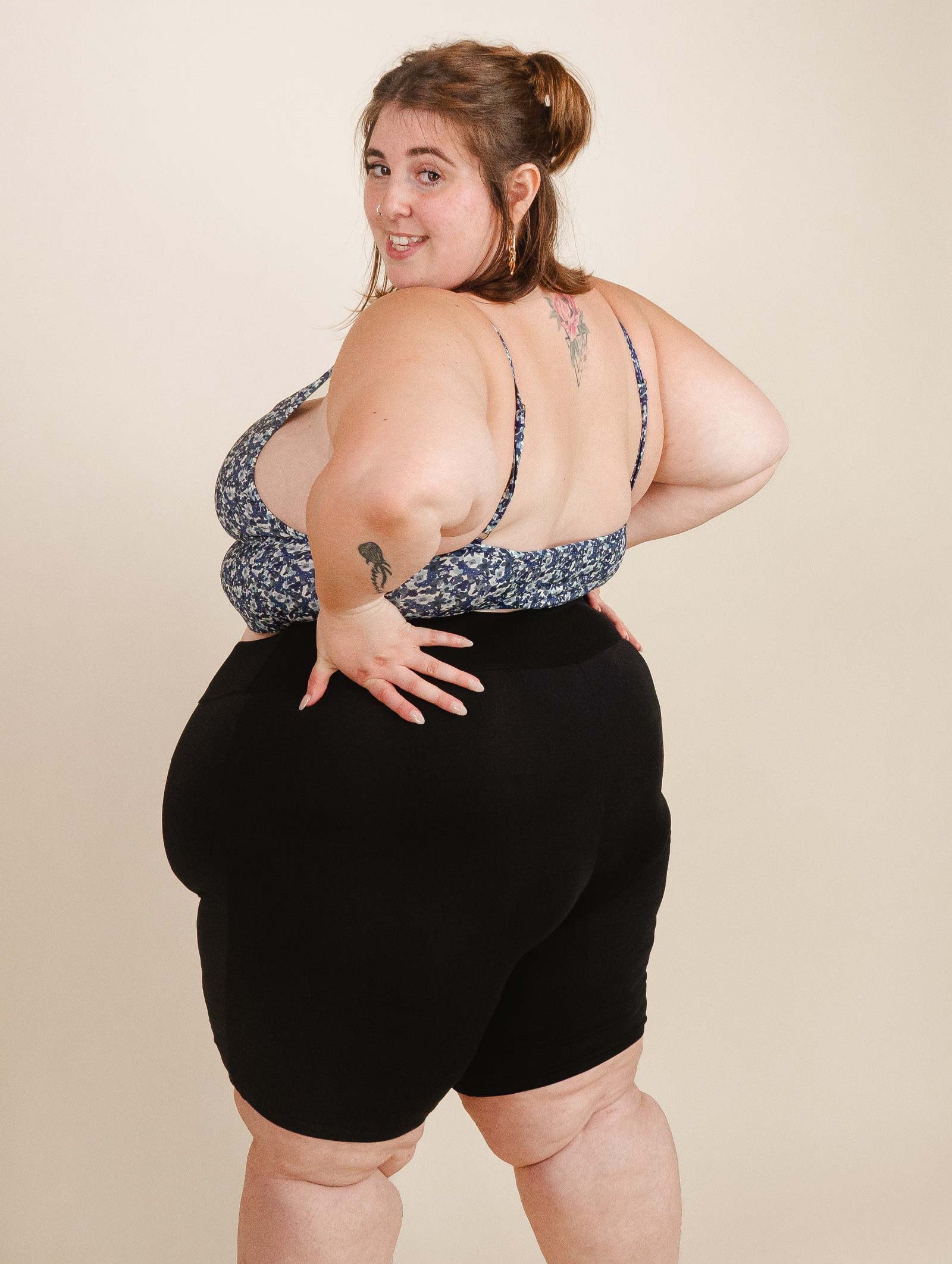 A woman in Riviera swim shorts by mimi and august posing for a photo.