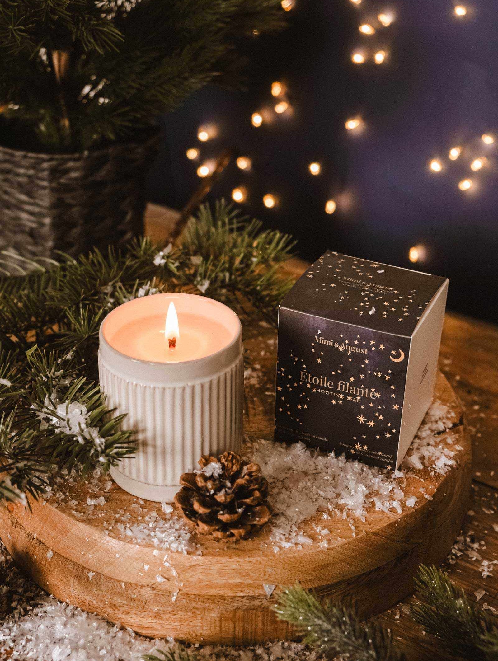 Shooting Star Christmas Candle in ceramic jar with festive pine and chestnut scent glowing softly