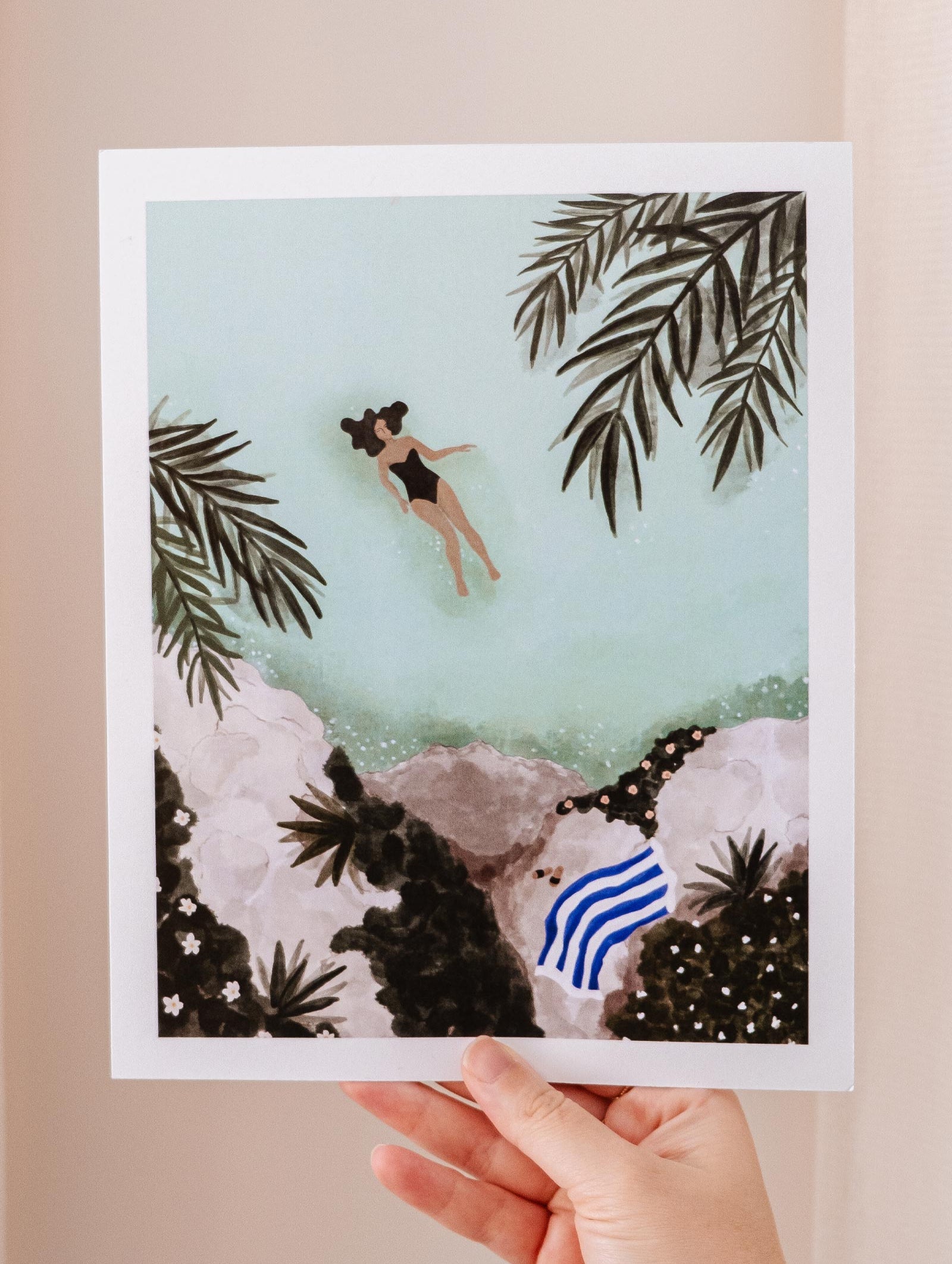 A hand holding a Swimming Art Print by Mimi & August.