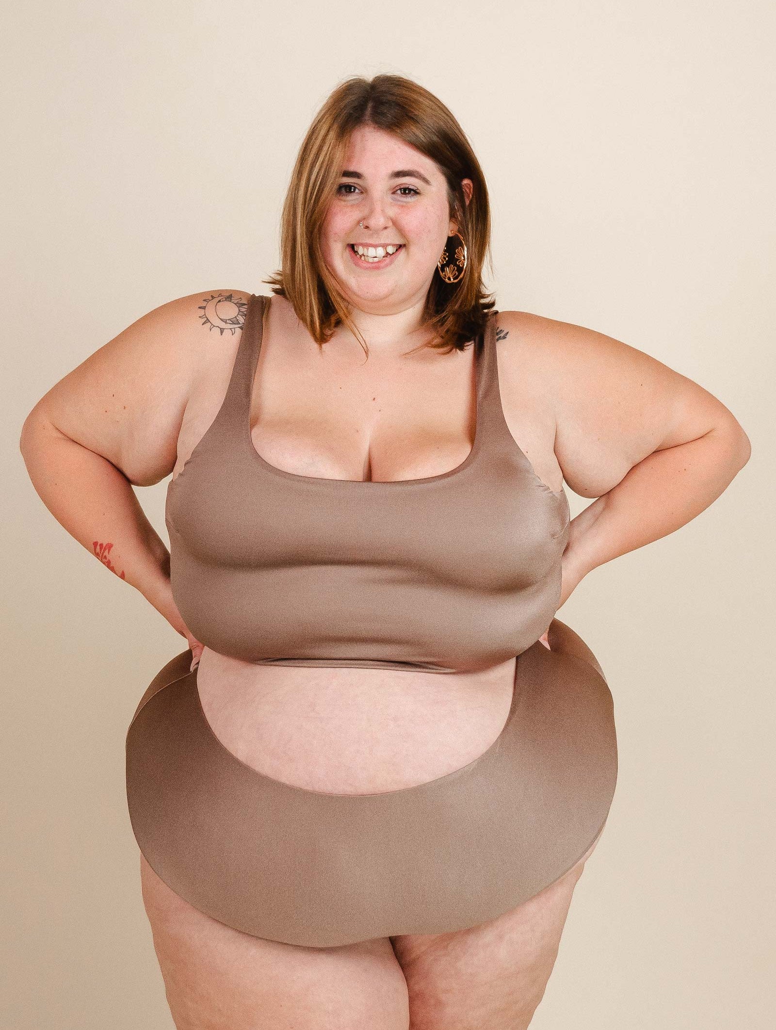 A plus size woman in a brown Tahiti Dunes Bralette Bikini Top by mimi and august posing for a photo.