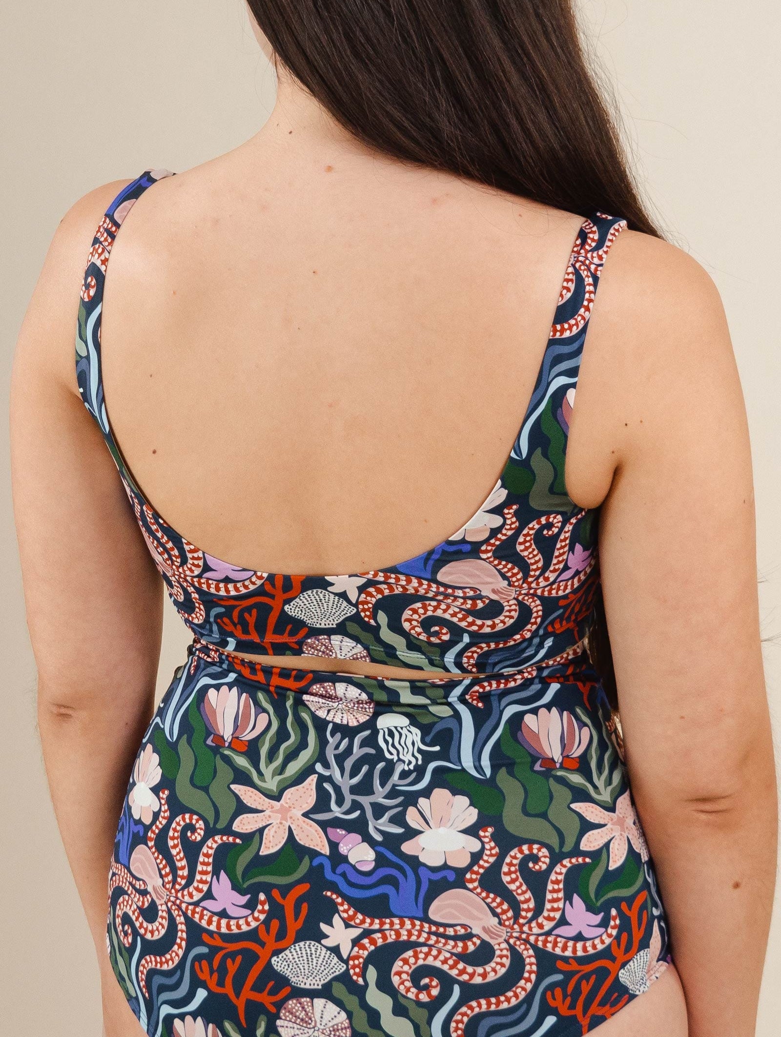 The back of a woman in a Tahiti Oceana Bralette swimsuit by mimi and august.