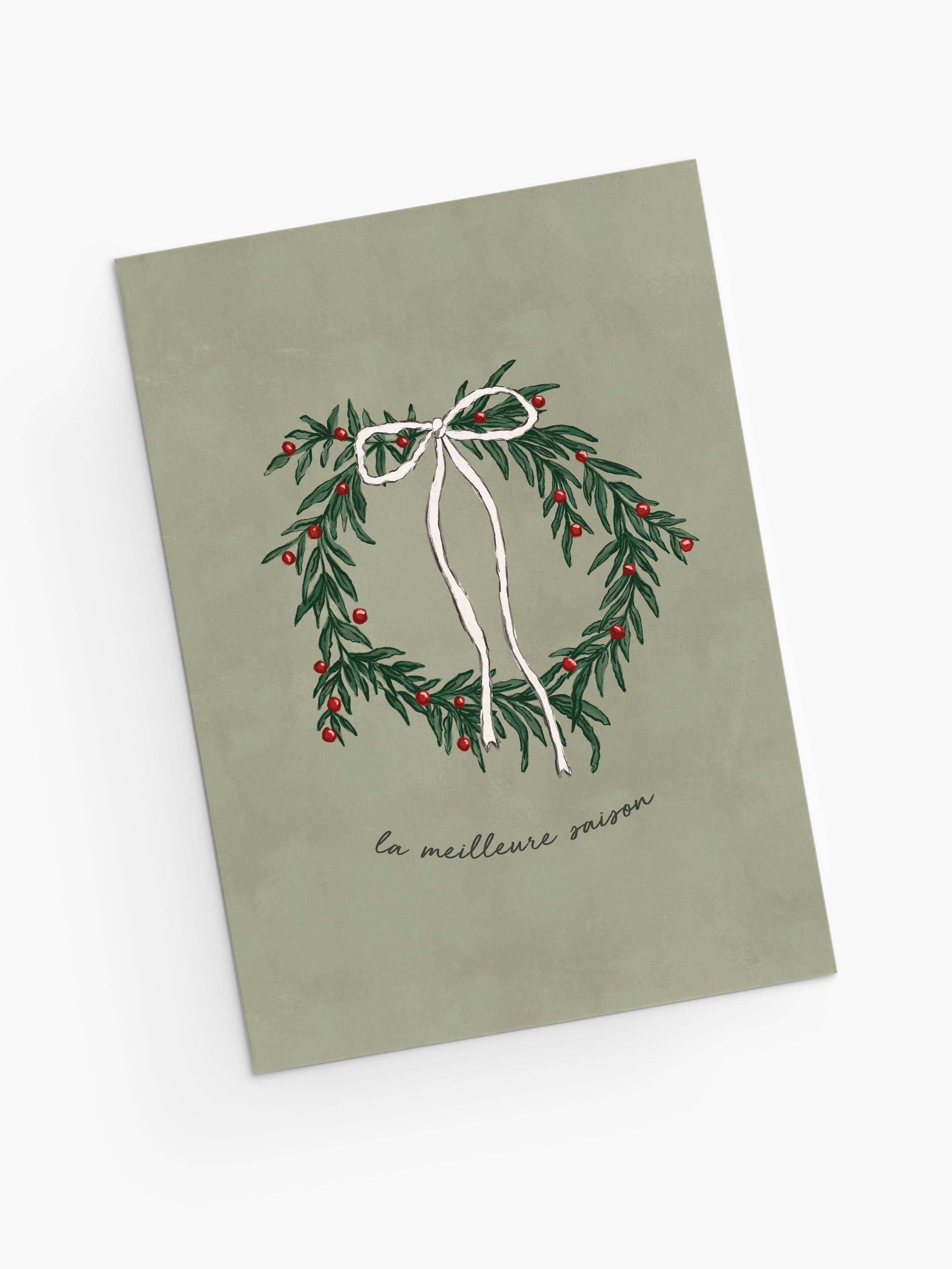 The Best Season Christmas Greeting Card by Mimi & August features an illustrated wreath with a white bow and red berries, “la meilleure saison” text on muted green, is blank inside for your message, and printed on recycled paper.