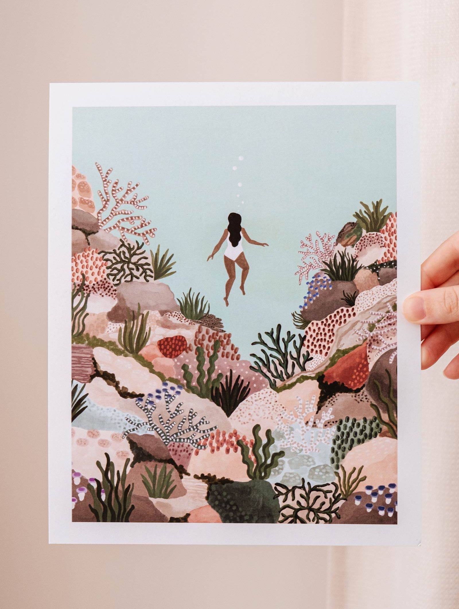 A woman holding the Under the sea Art Print by Mimi & August.