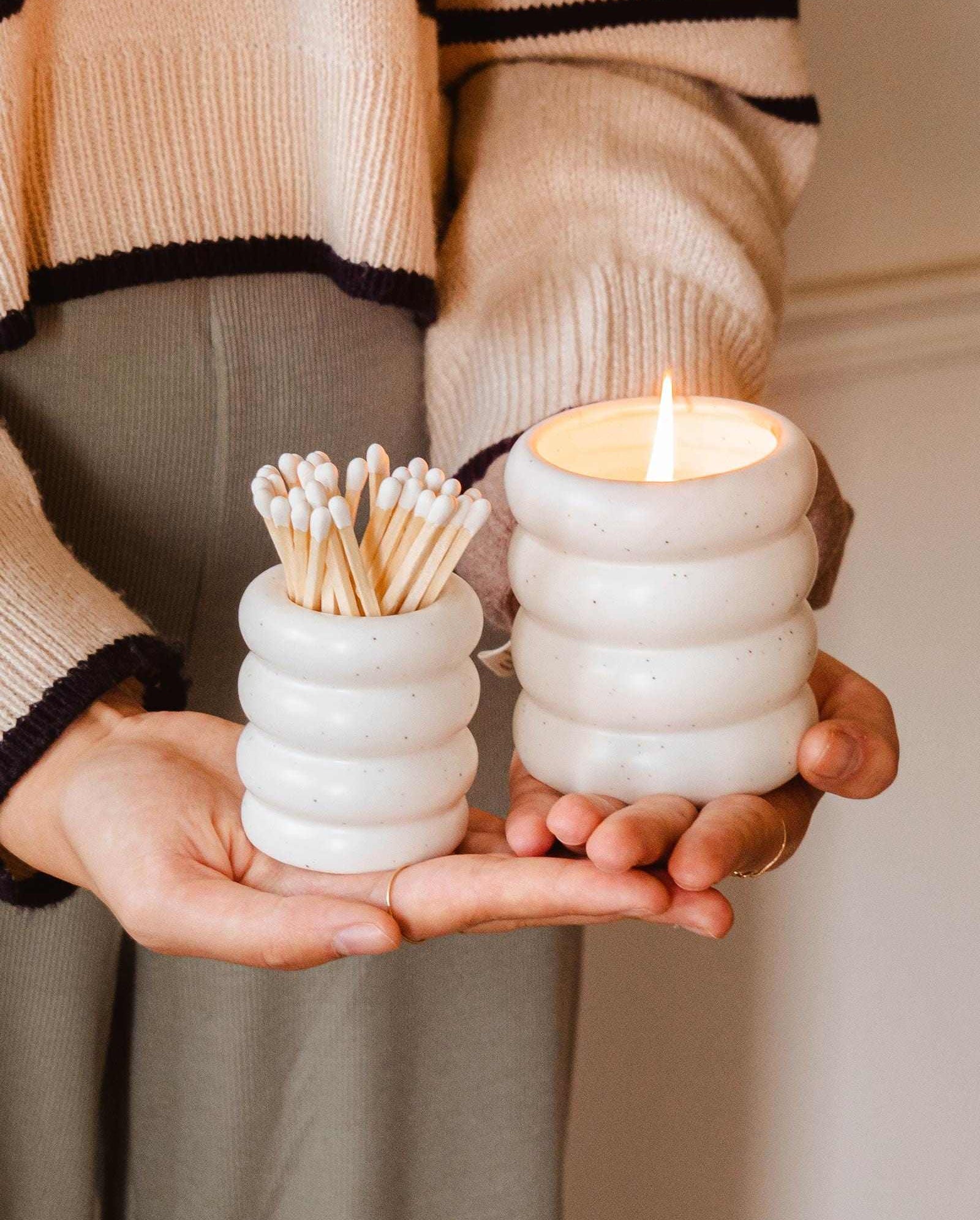 A woman holding a Mimi & August Ceramic Match Pot with matches.