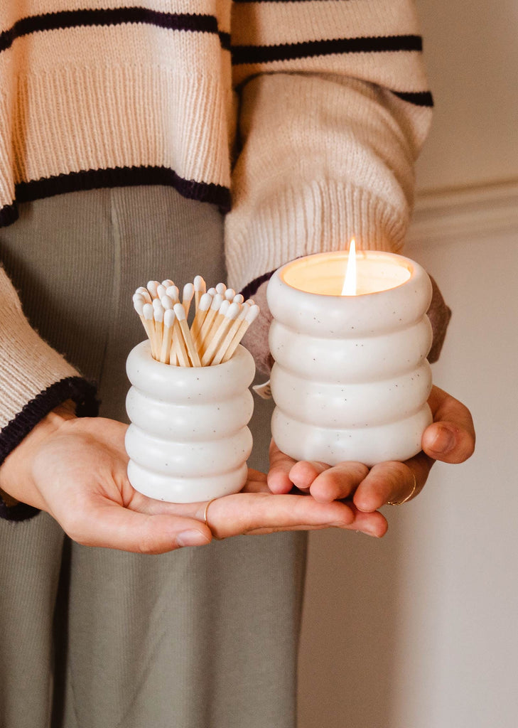 A woman holding a Mimi & August Ceramic Match Pot with matches.