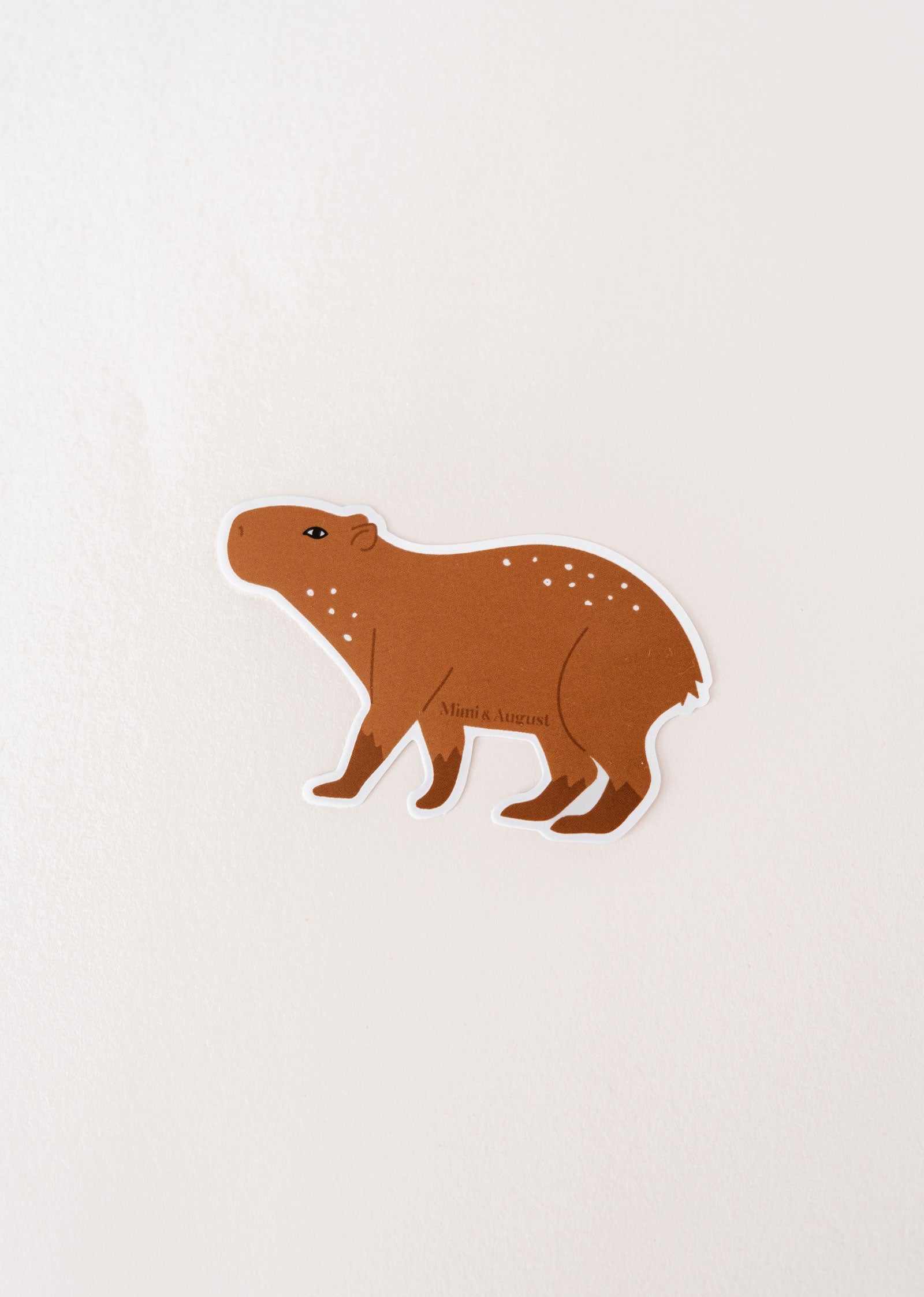 A waterproof Mimi & August vinyl sticker featuring a Capybara on a white surface.
