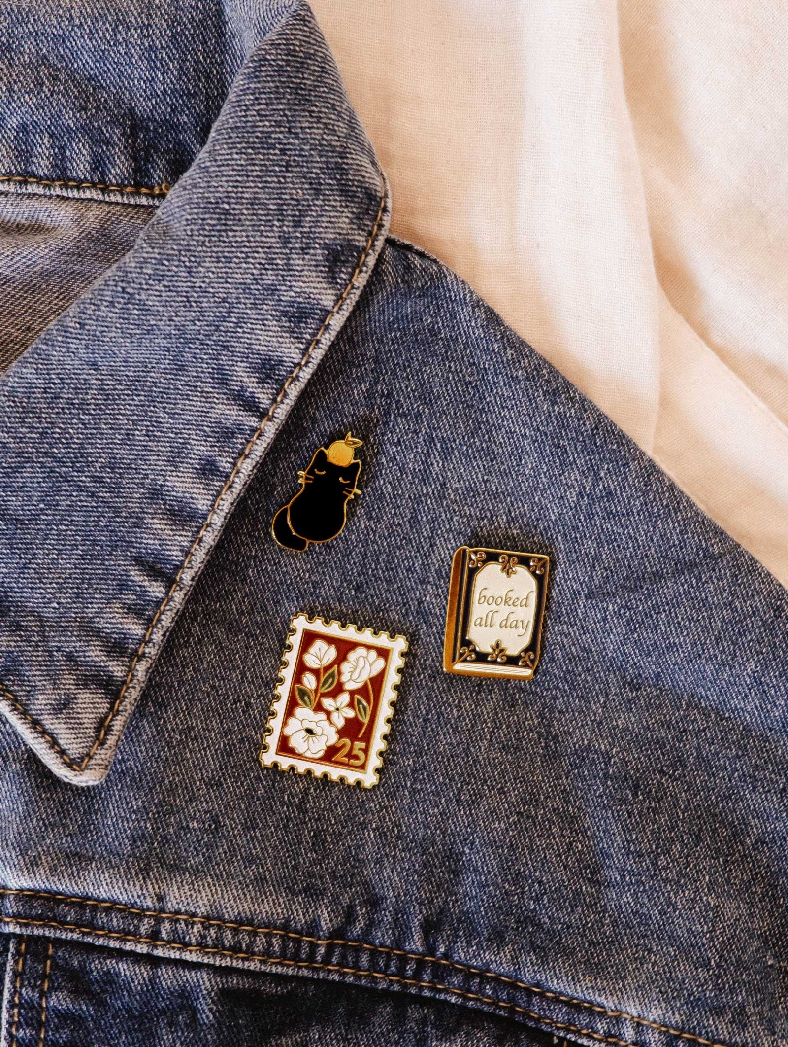 Add a playful touch to your blue denim jacket with the Floral Stamp Enamel Pin by Mimi & August—a charming accessory that brings everyday style to life.