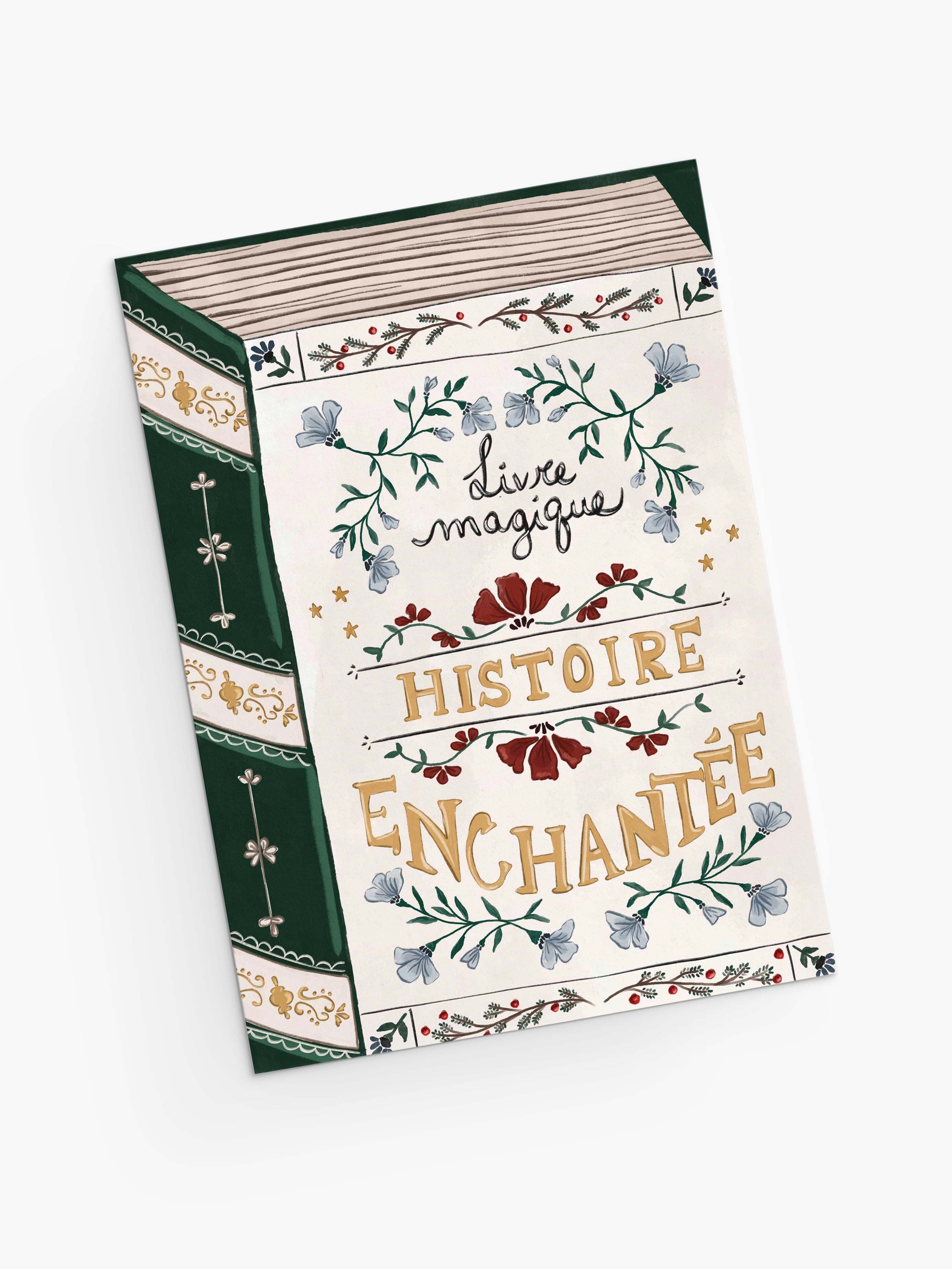 An eco-friendly Christmas greeting card by Mimi & August, "Enchanted Book," features ornate floral designs and decorative gold and black lettering on the cover, printed on recycled paper.