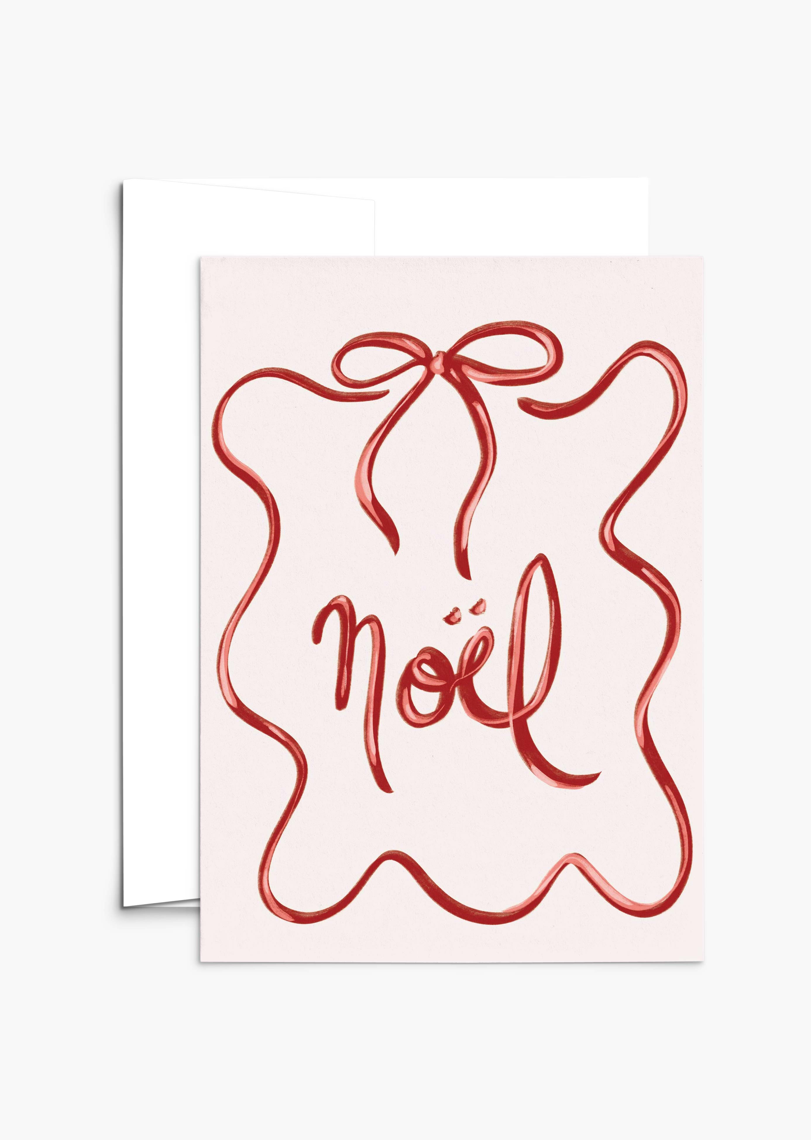 The Mimi & August Christmas Bow Greeting Card features a red ribbon design and “noël” in cursive, comes with a white envelope, and is printed on recycled paper. The card is blank inside for your personal message.