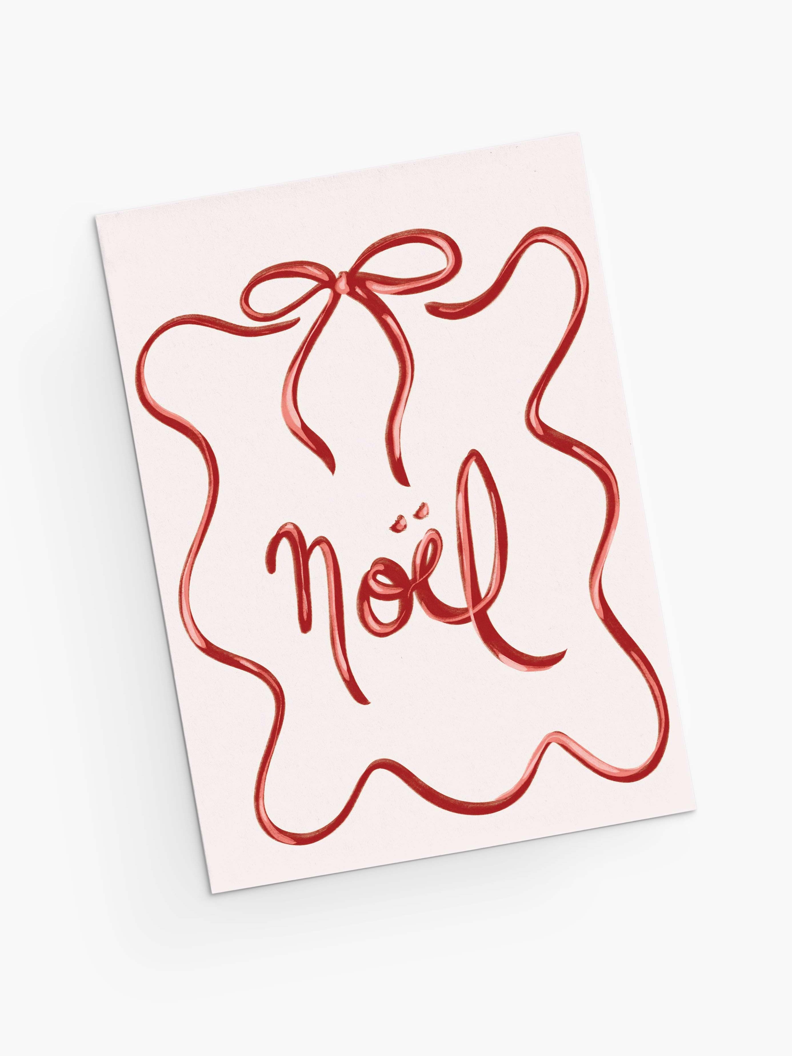 The Mimi & August Christmas Bow Greeting Card features "Noël" in red cursive, framed by a red squiggly ribbon like a gift bow. Printed on recycled paper, it's blank inside for your personal message.
