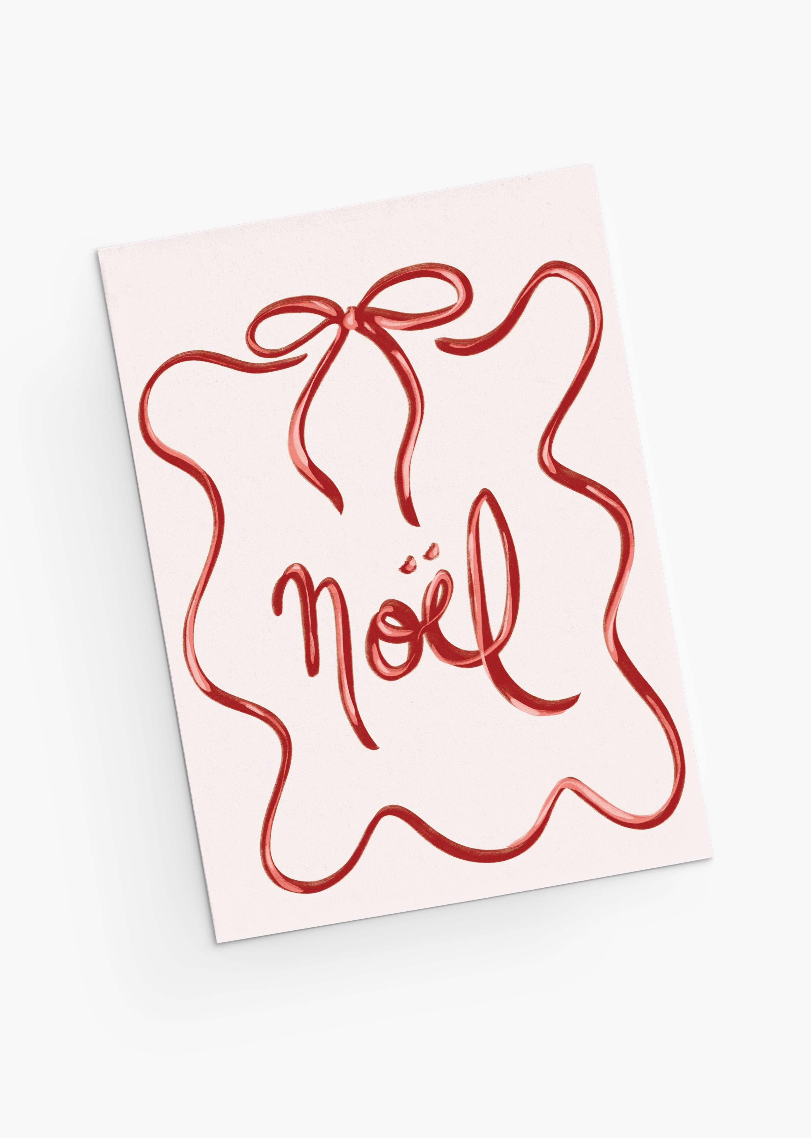 The Mimi & August Christmas Bow Greeting Card features "Noël" in red cursive, framed by a red squiggly ribbon like a gift bow. Printed on recycled paper, it's blank inside for your personal message.