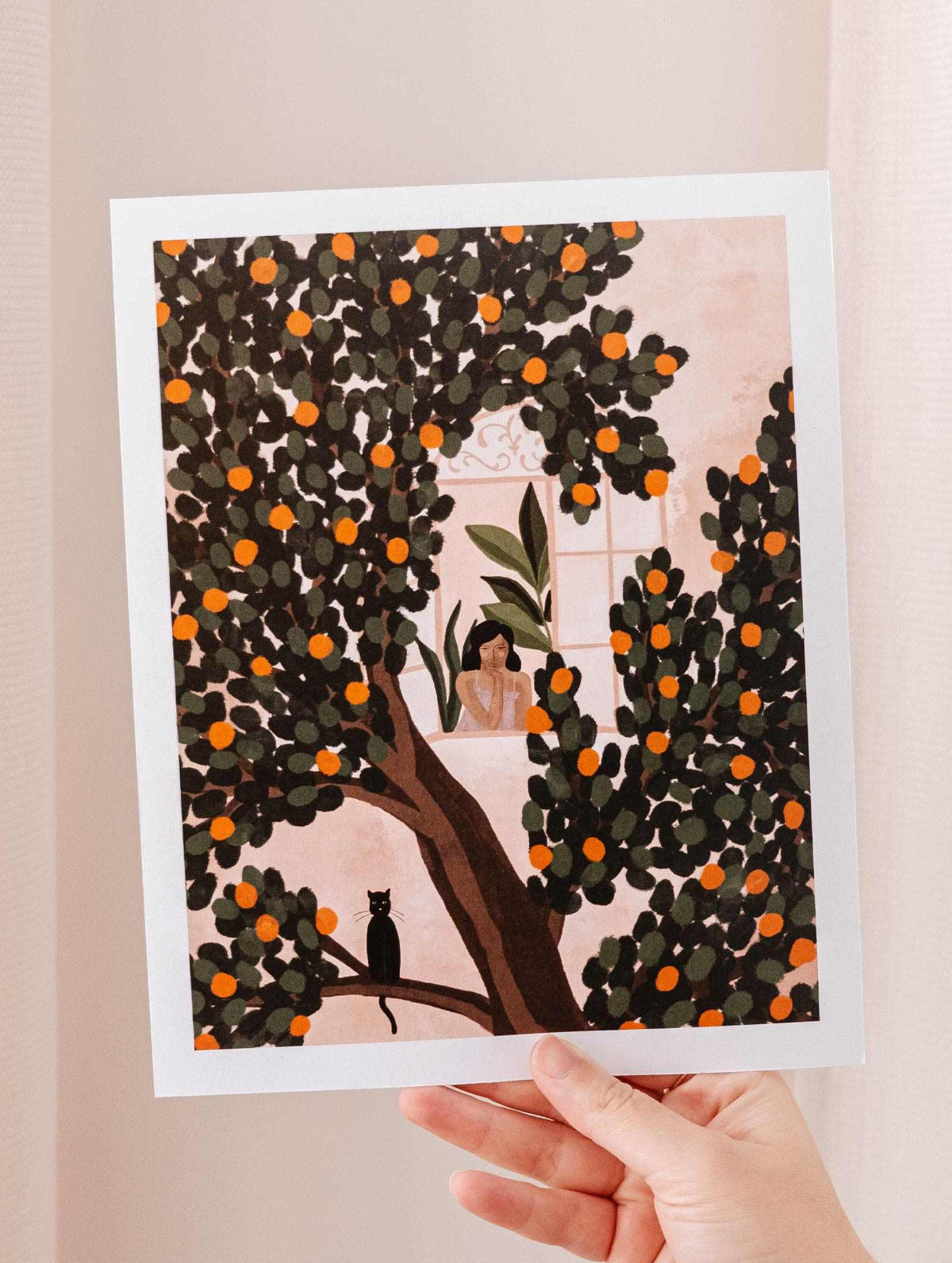 A woman admiring a vibrant Mimi & August Orange Tree Art Print.