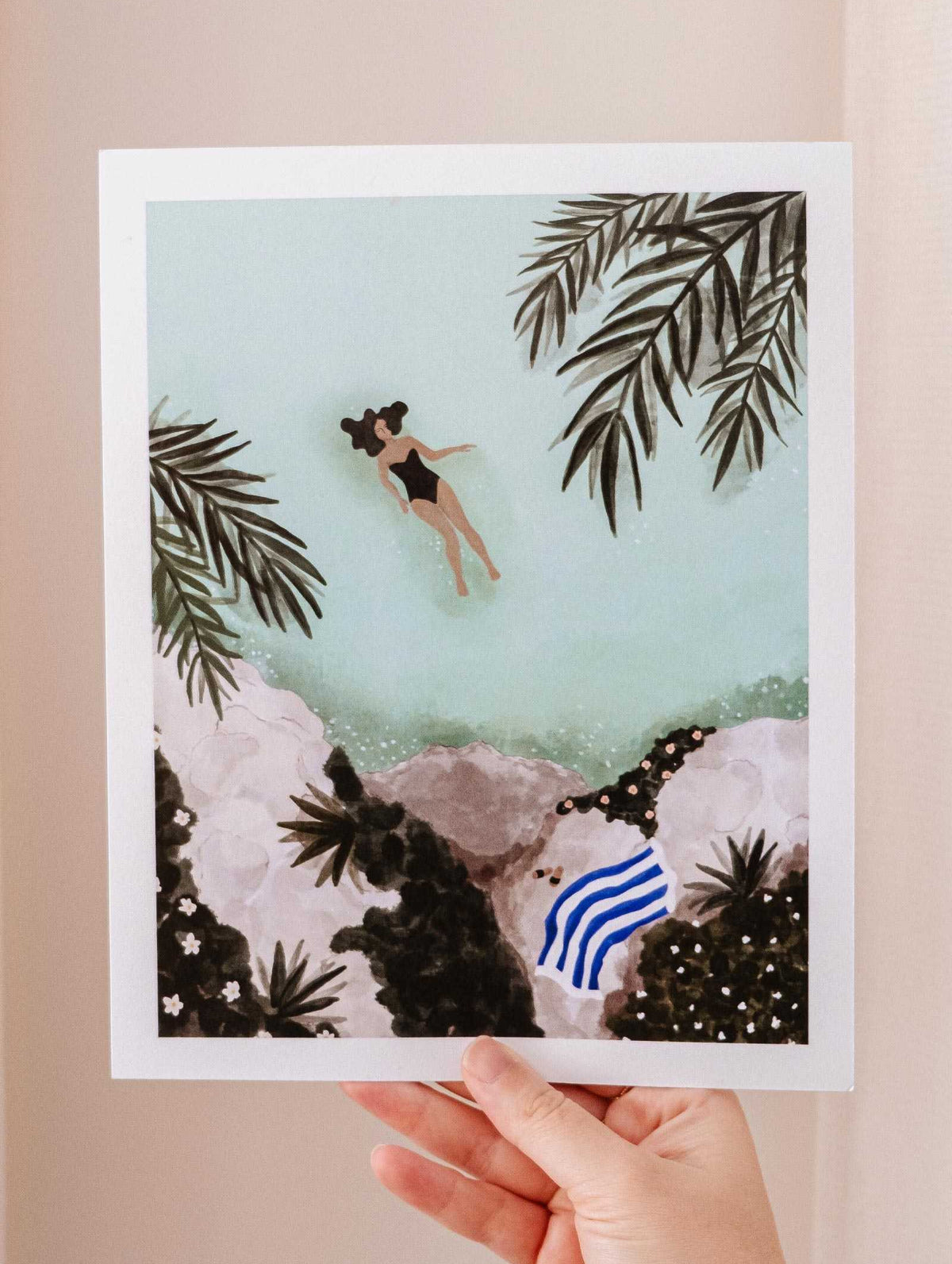 A hand holding a Swimming Art Print by Mimi & August.
