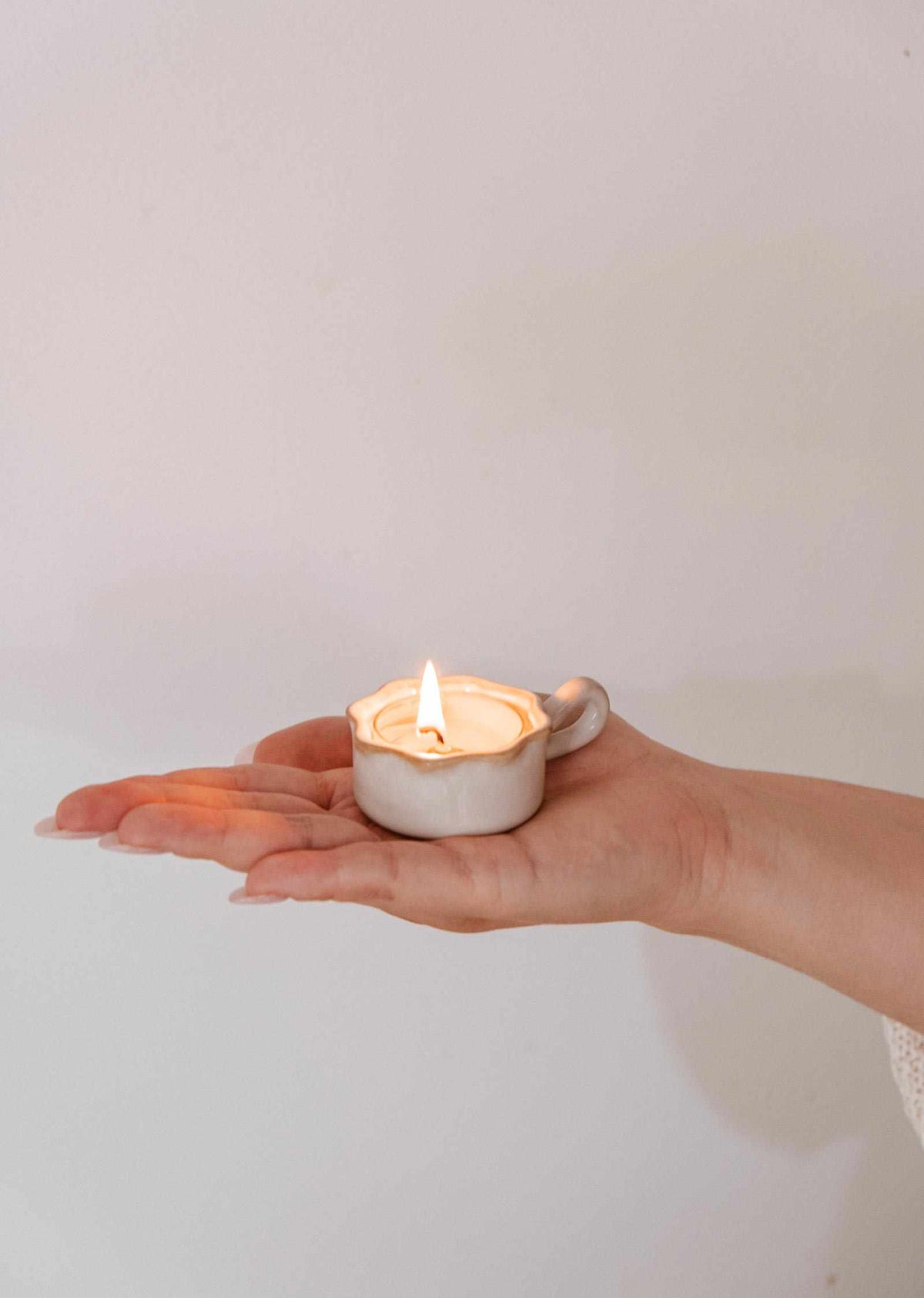 Porte-lampion ondulé en céramique artisanale crème avec rebord brun grillé et petite anse, parfait pour lampions standard.