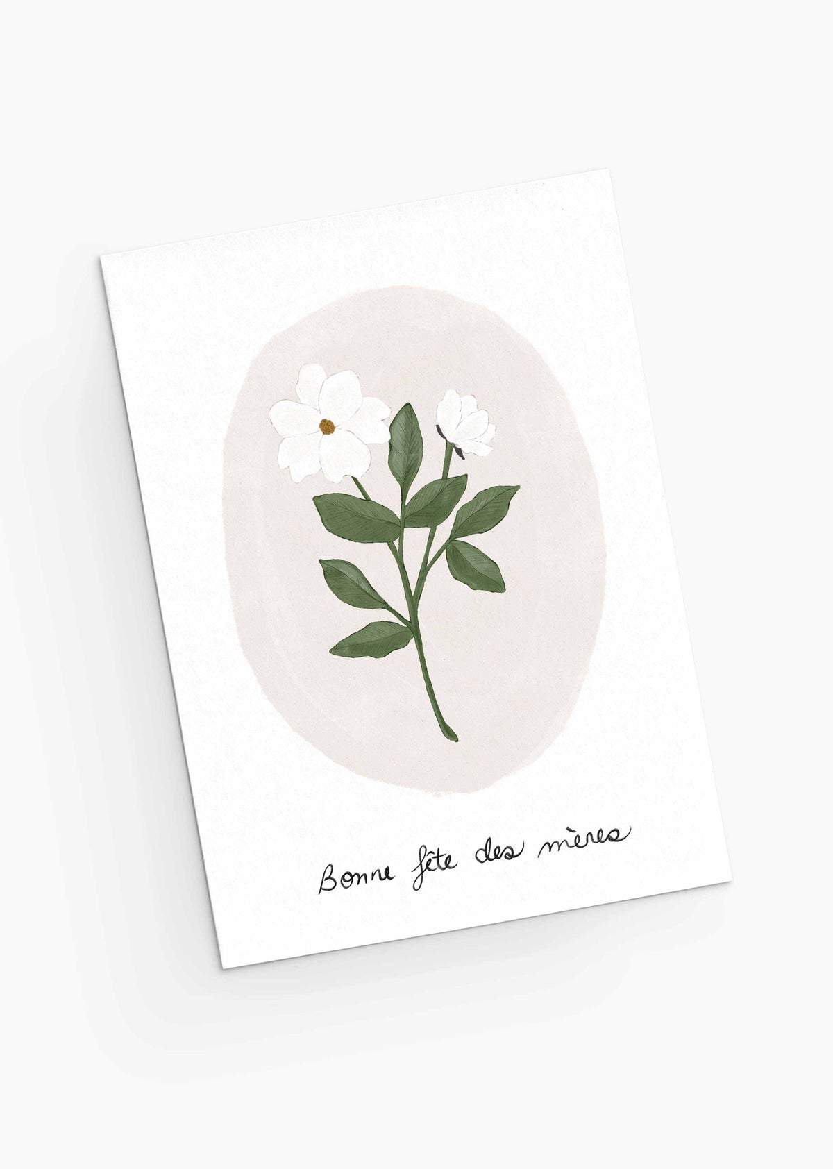 The White Flower Mother's Day Greeting Card from Mimi & August is crafted from recycled paper, featuring a white flower and green leaves illustration with the French greeting "Bonne fête des mères," conveying the delicate charm of pastel blooms.